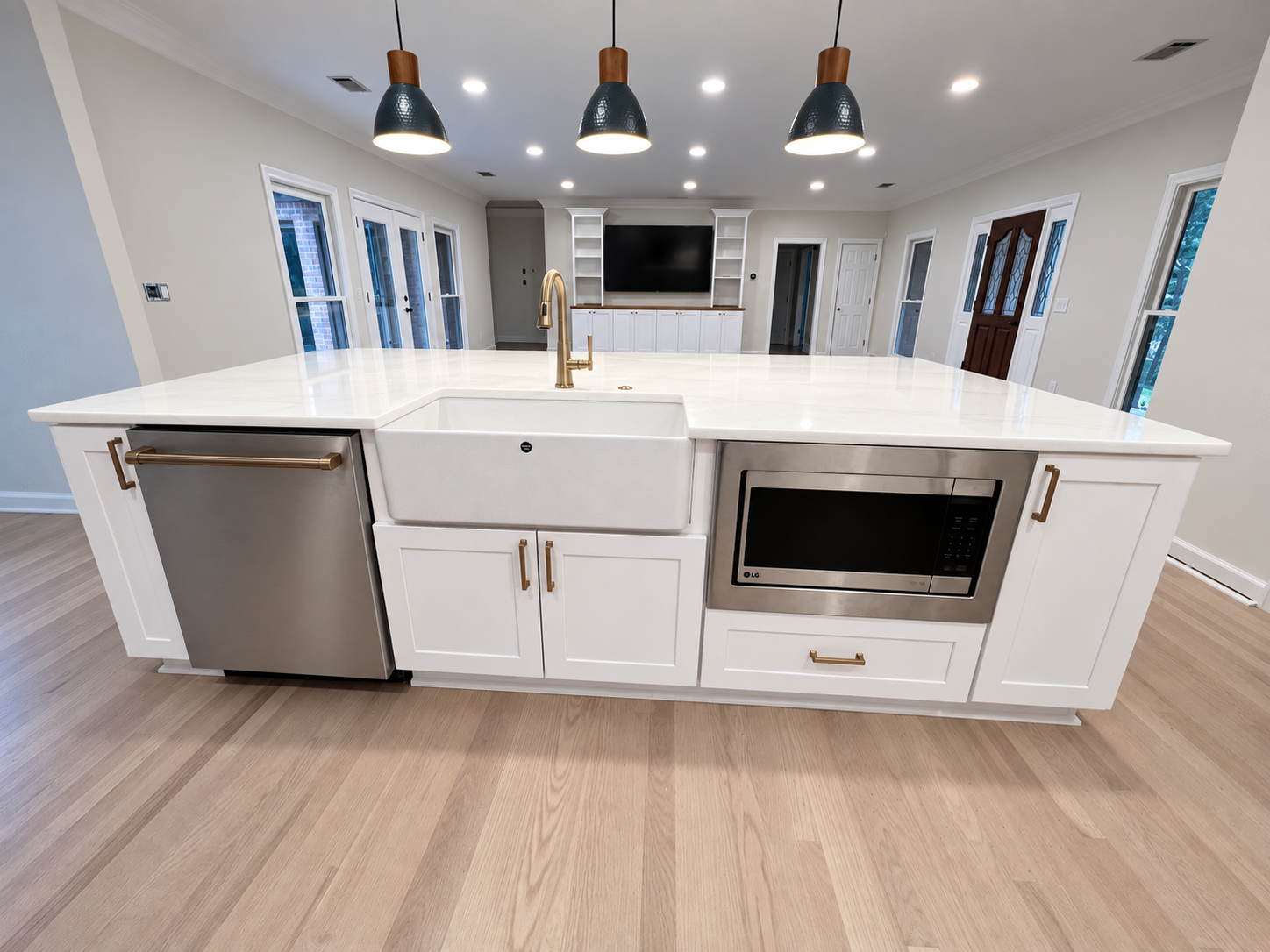 White kitchen island with farmhouse sink and brass hardware
