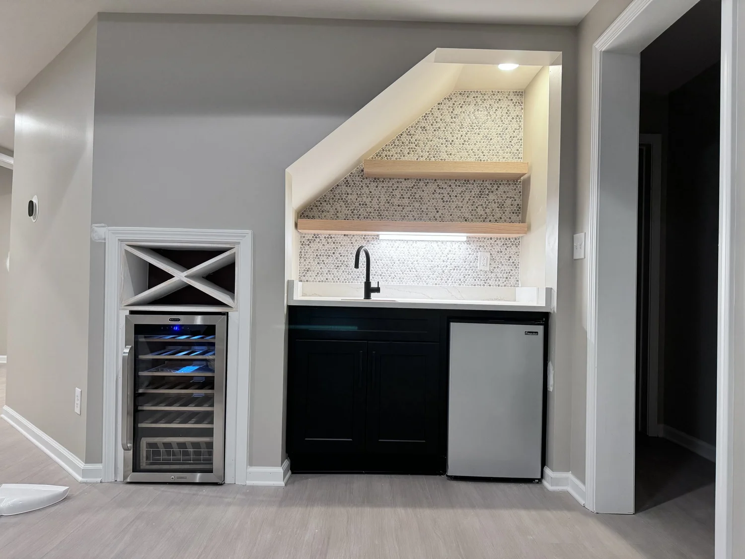 Compact wet bar with wood shelves and mosaic backsplash