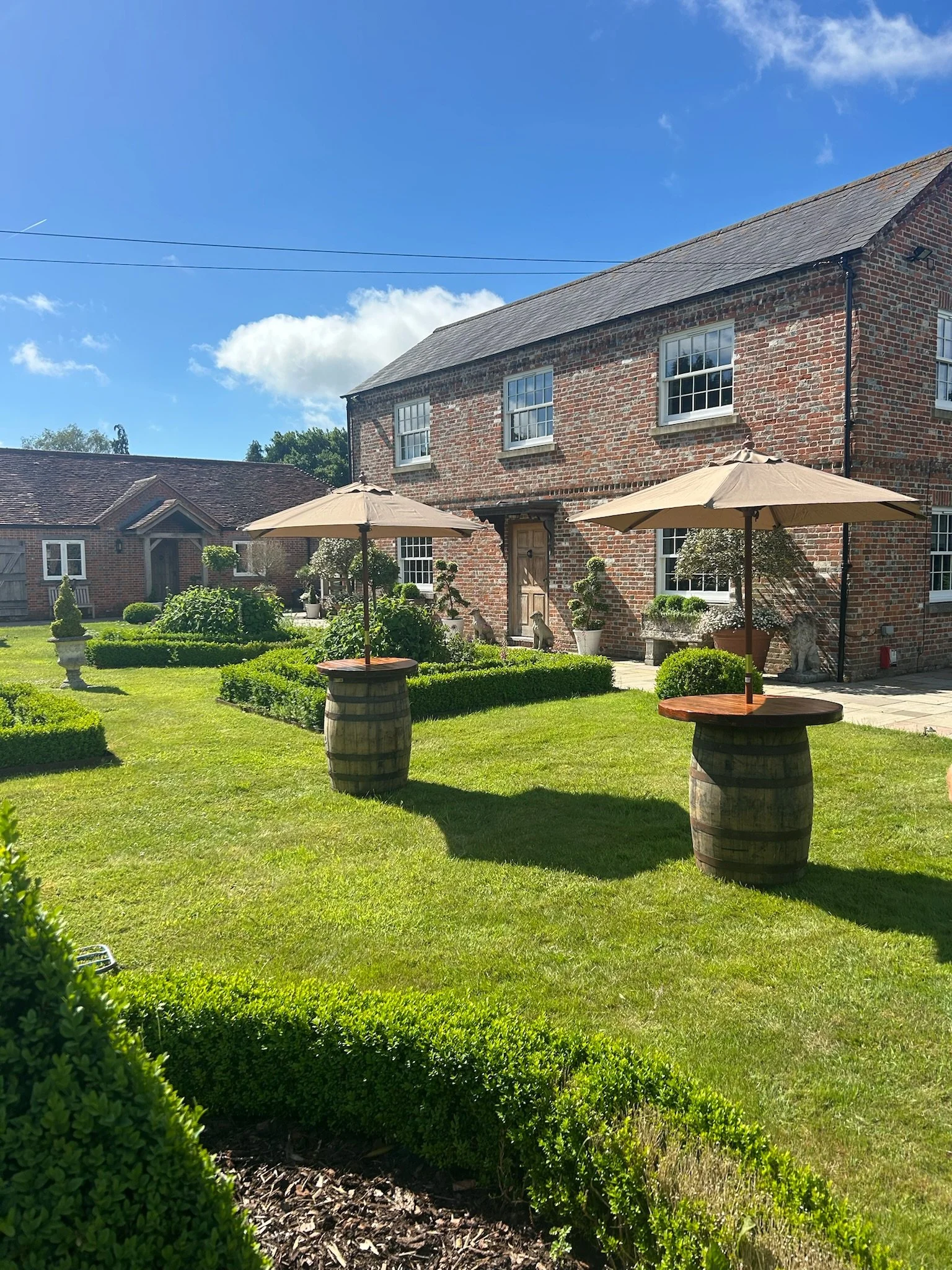 Our barrels complimented with rustic wooden tops and taupe parasols are great for summer drinks