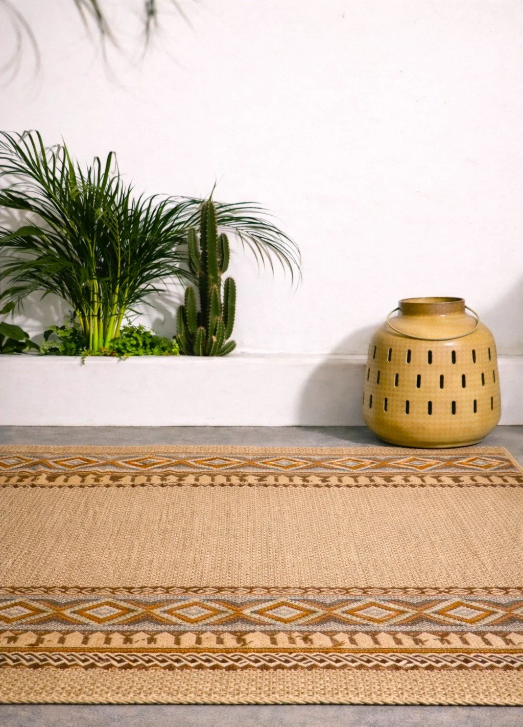 Zimmer mit grünem Pflanzen und Keramiktopf auf einem Teppich auf dem Boden.