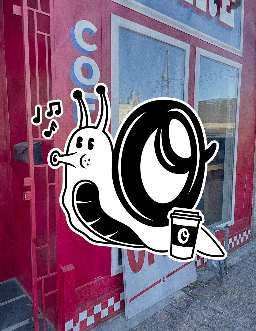 A sticker of a cartoon snail with a coffee cup attached to its shell, placed on a pink wall with a window behind it.