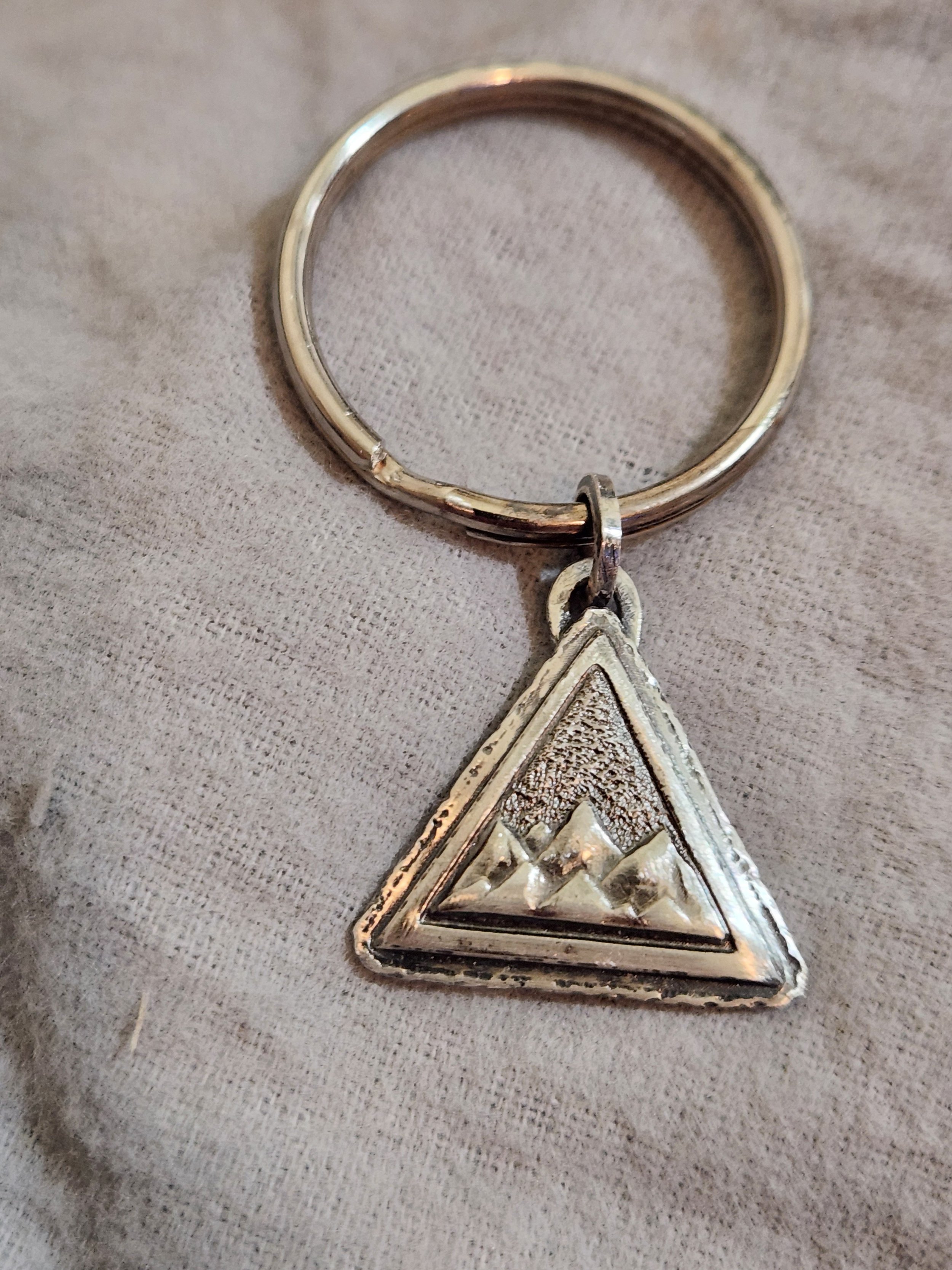 Die-struck sterling silver keychain featuring a triangular mountain range charm.