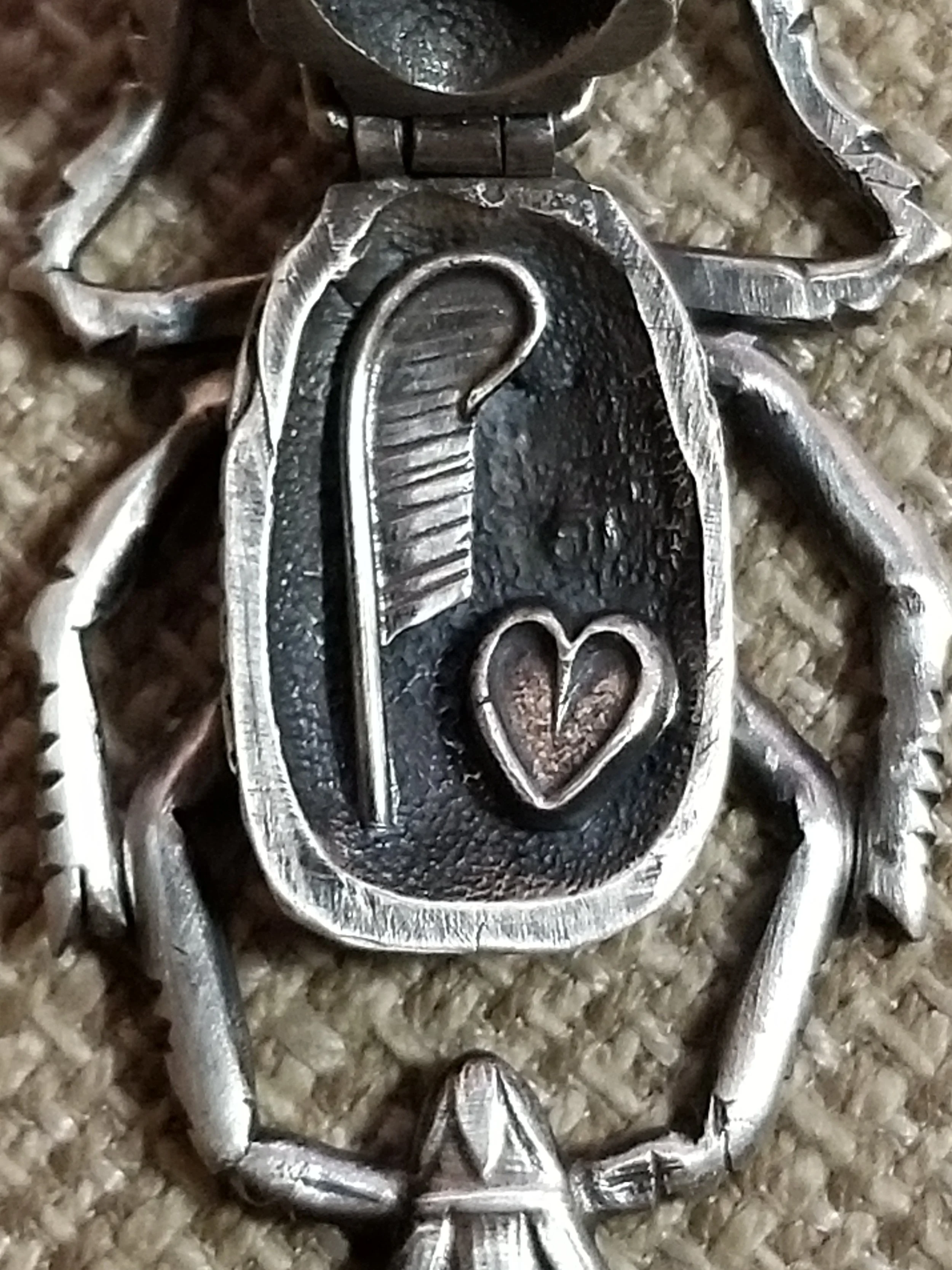 Closeup of sterling silver scarab beetle locket featuring fabricated, hand cast, and die struck elements.