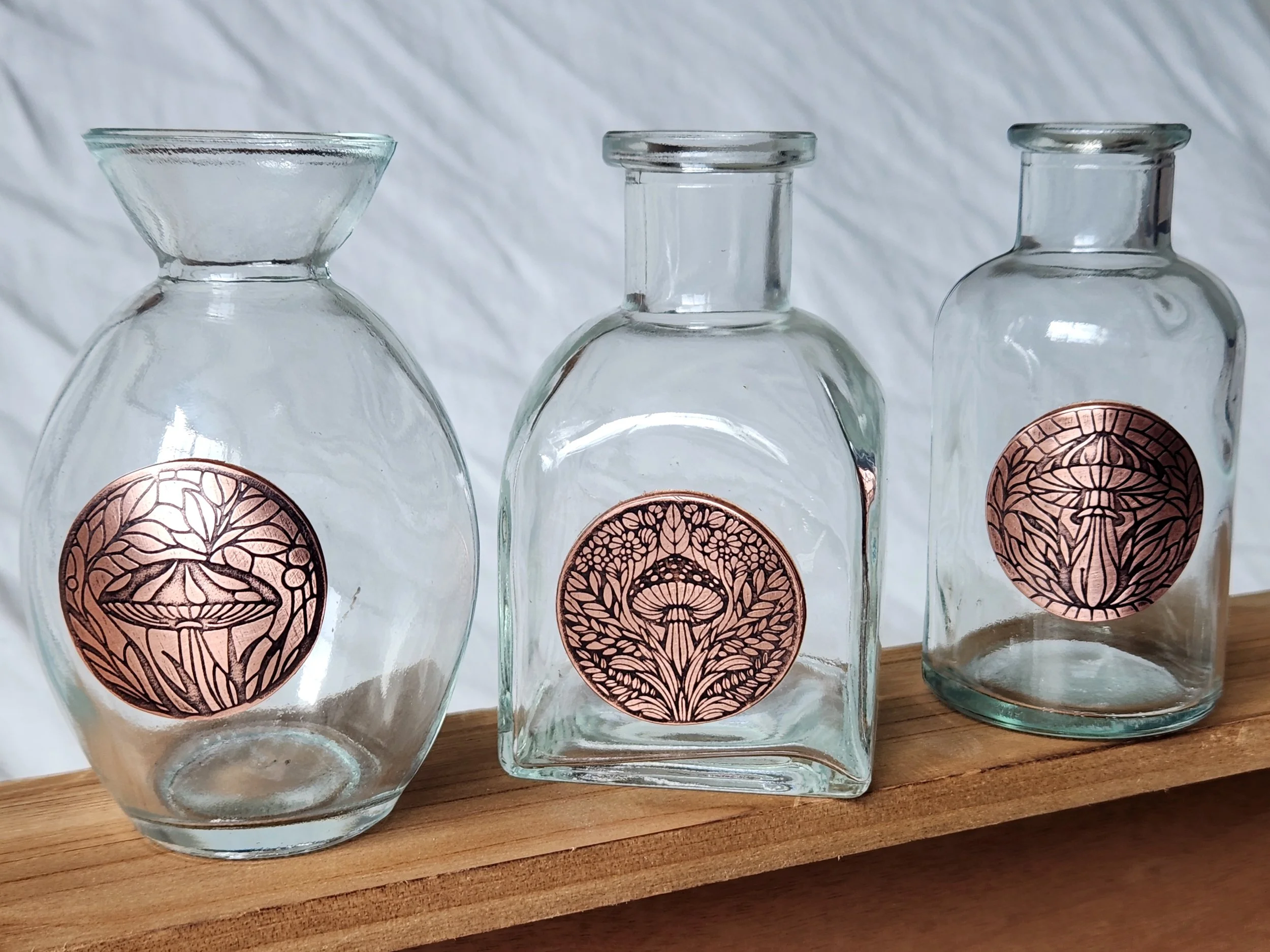 Three propagation vases with roll-printed and oxidized copper images of mushrooms.
