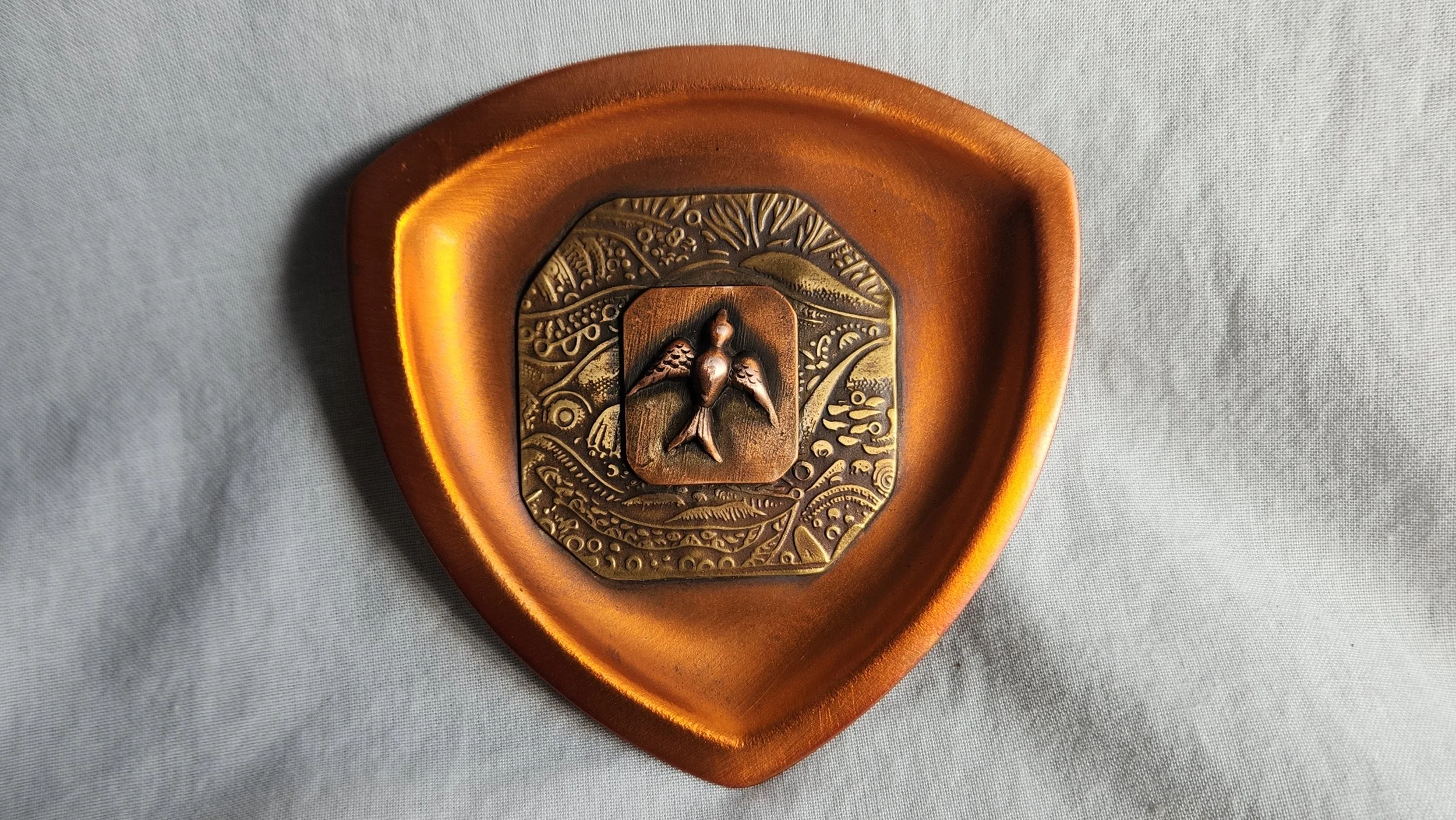 Die-struck copper trinket dish with textured brass and hand sawn bird.