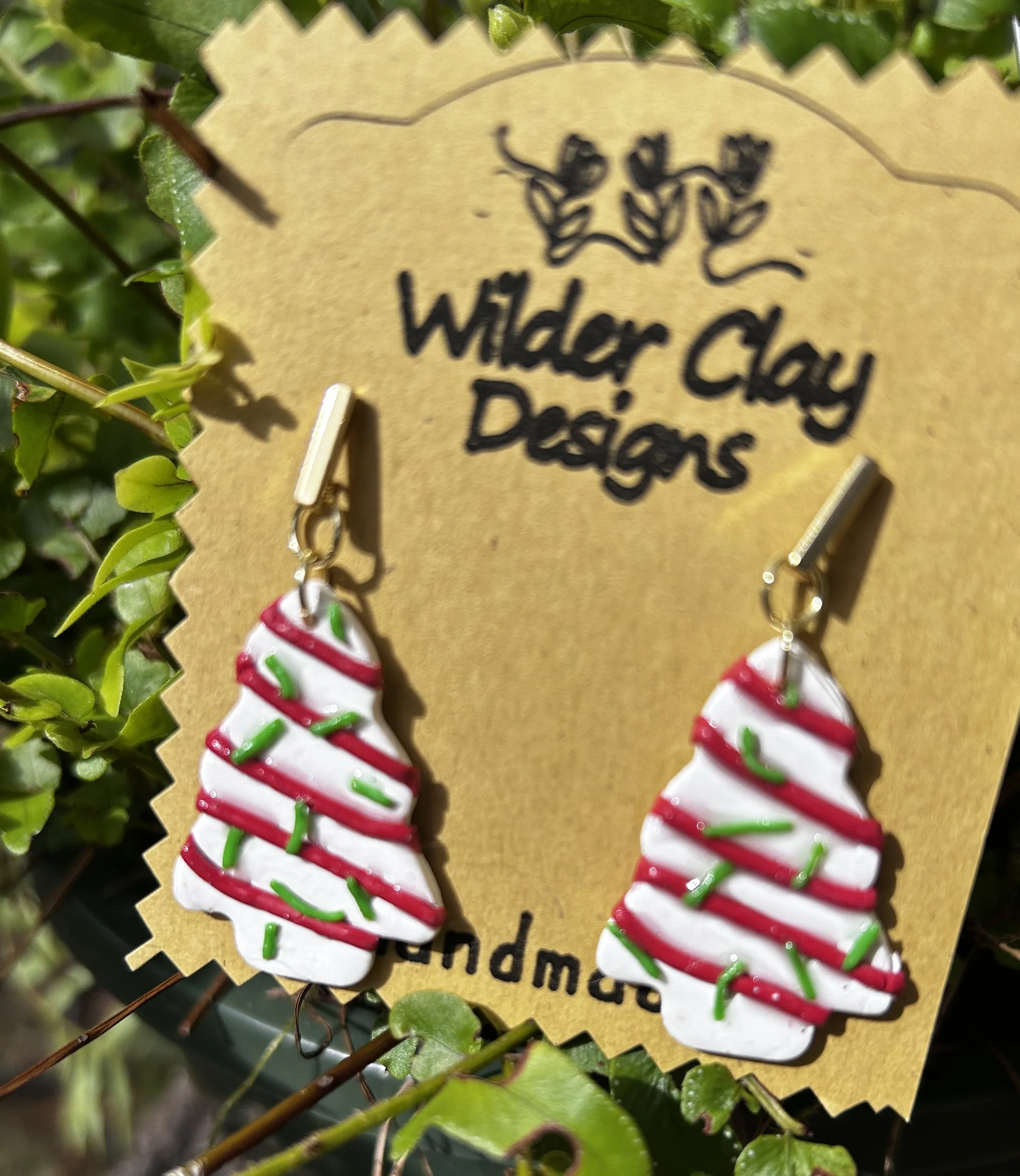 Handmade Christmas tree earrings with white, red, and green striped icing design. Looking just like the Little Debbie cakes!