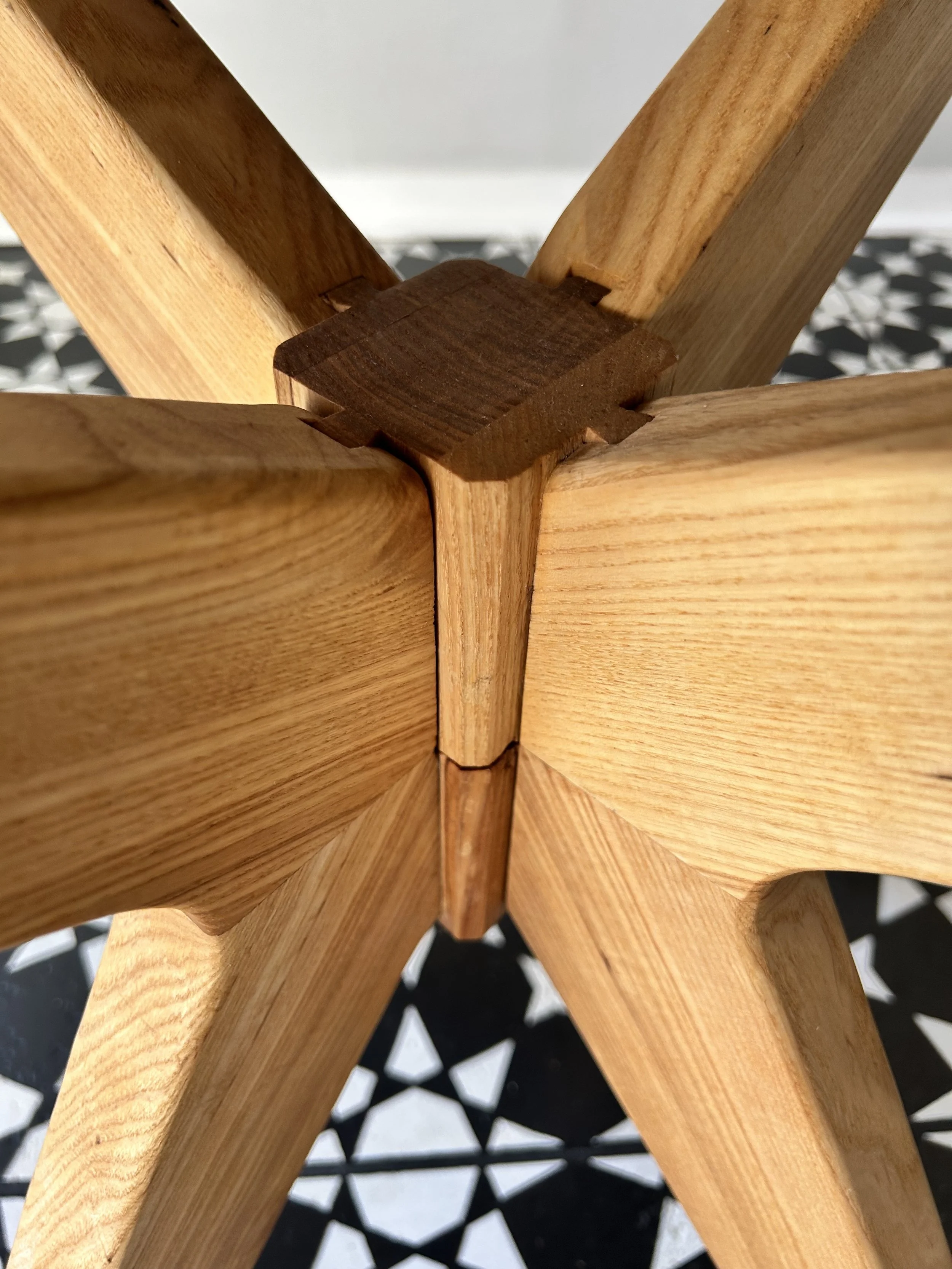 Close-up view of a wooden furniture dove tail joint, showing interlocking pieces of wood at the corner.