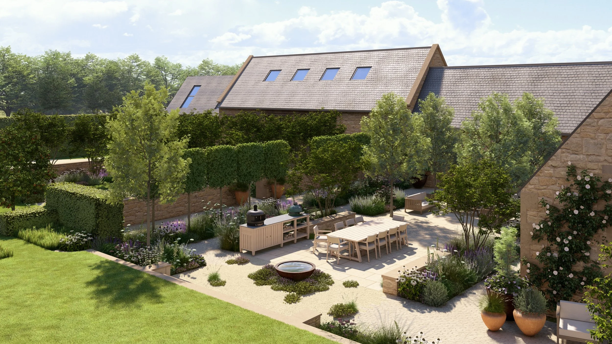 A landscaped paved courtyard garden of a Cotswold barn conversion with a ten person dining table and chairs, outdoor kitchen, sofas, lot of flowers, perennial grasses in large naturalistic planting beds and a row of pleached evergreen trees.