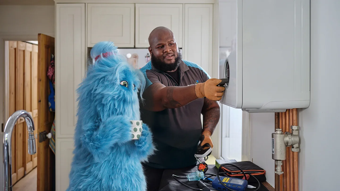 British Gas Engineer with blue British Gas mascot, drinking tea