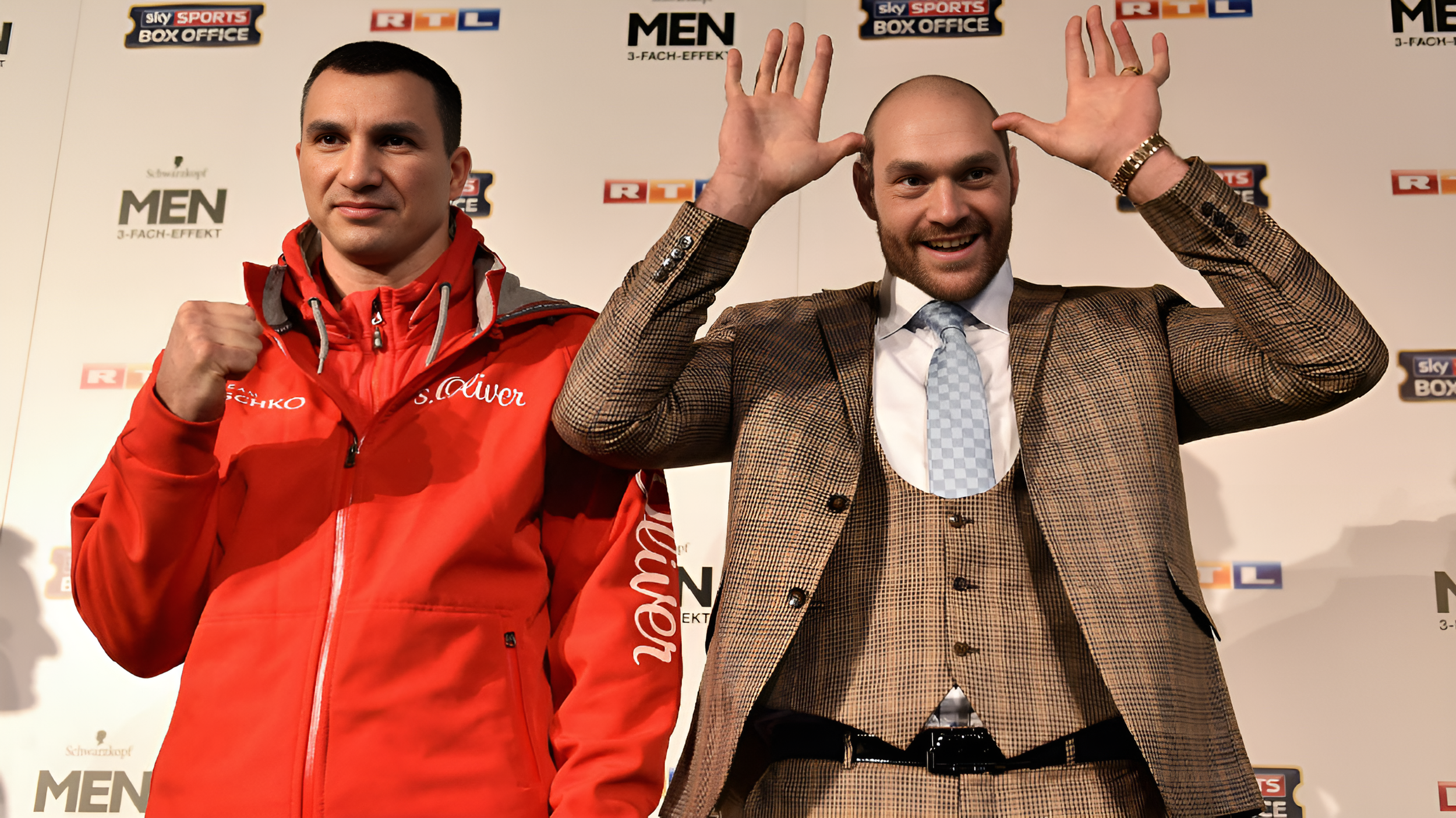 Boxers Wladimir Klitschko and Tyson Fury standing next to each other at press conference, smiling