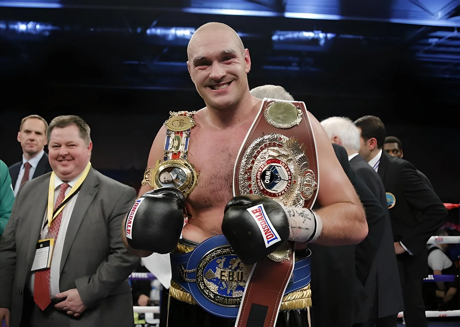 Tyson Fury smiling with belts over shoulders and on waist after beating Wladimir Klitschko