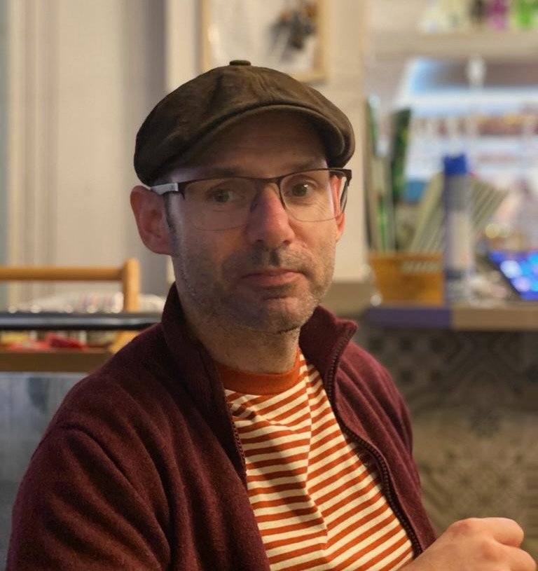 Man in cafe bar looking to camera