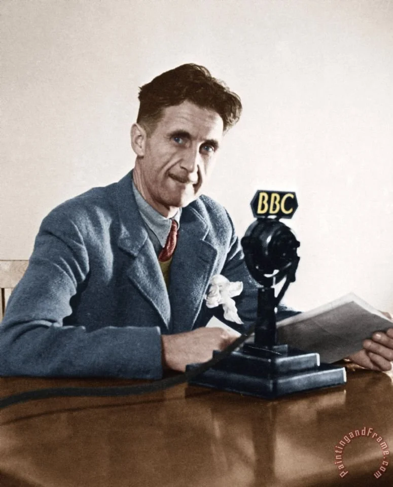 George Orwell in colour, sat at a desk with a BBC radio microphone