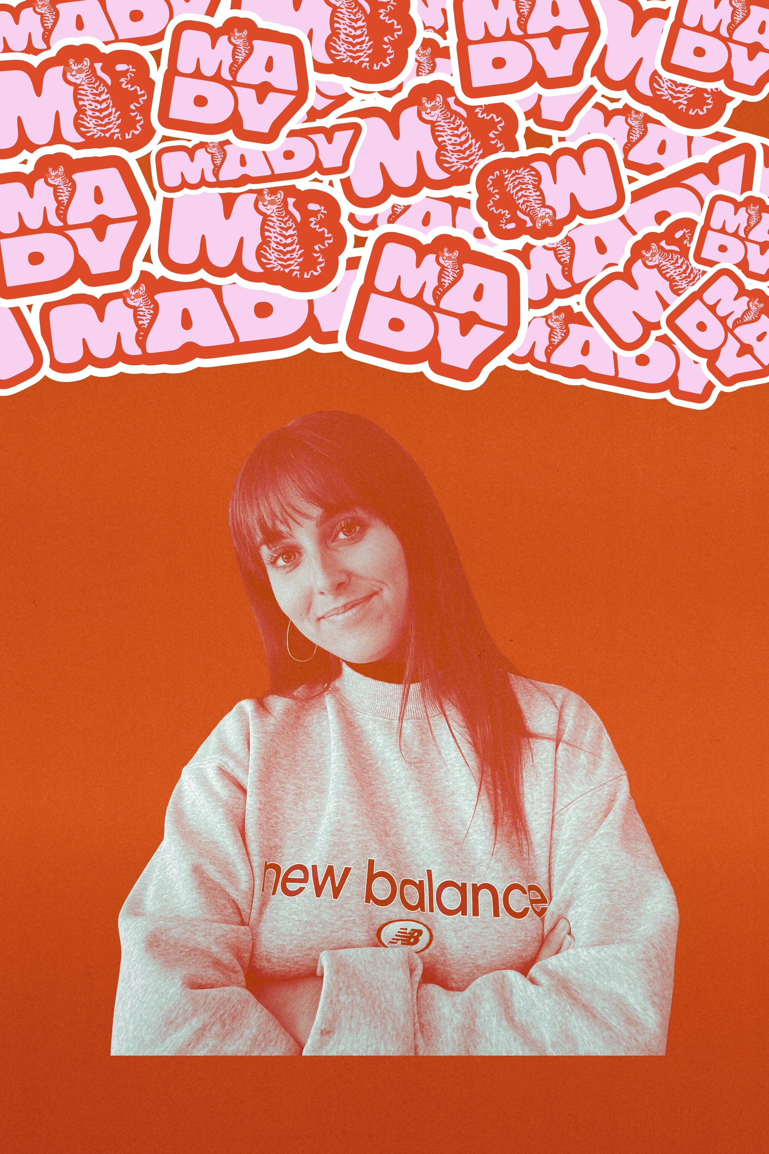 Une jeune femme avec un sweatshirt gris de la marque New Balance, souriant avec les bras croisés, devant un fond orange avec des autocollants en haut comportant le texte 'MADY' et un tigre en dessous.