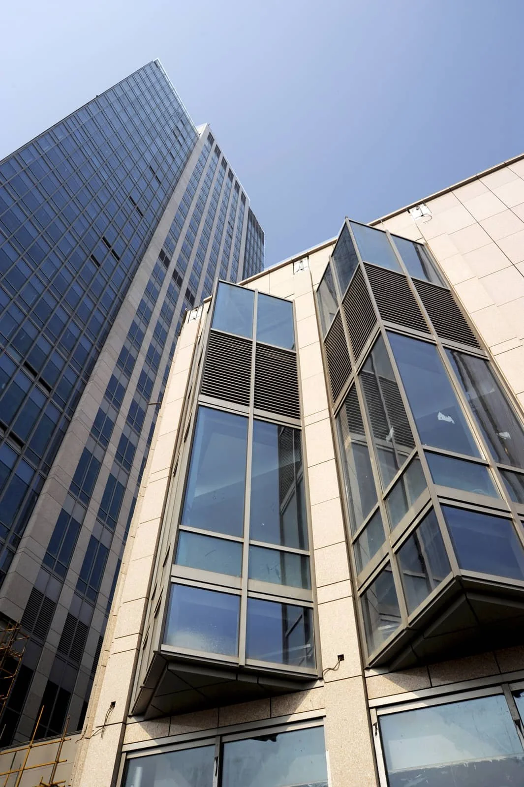 View of modern glass high-rise buildings against a blue sky.