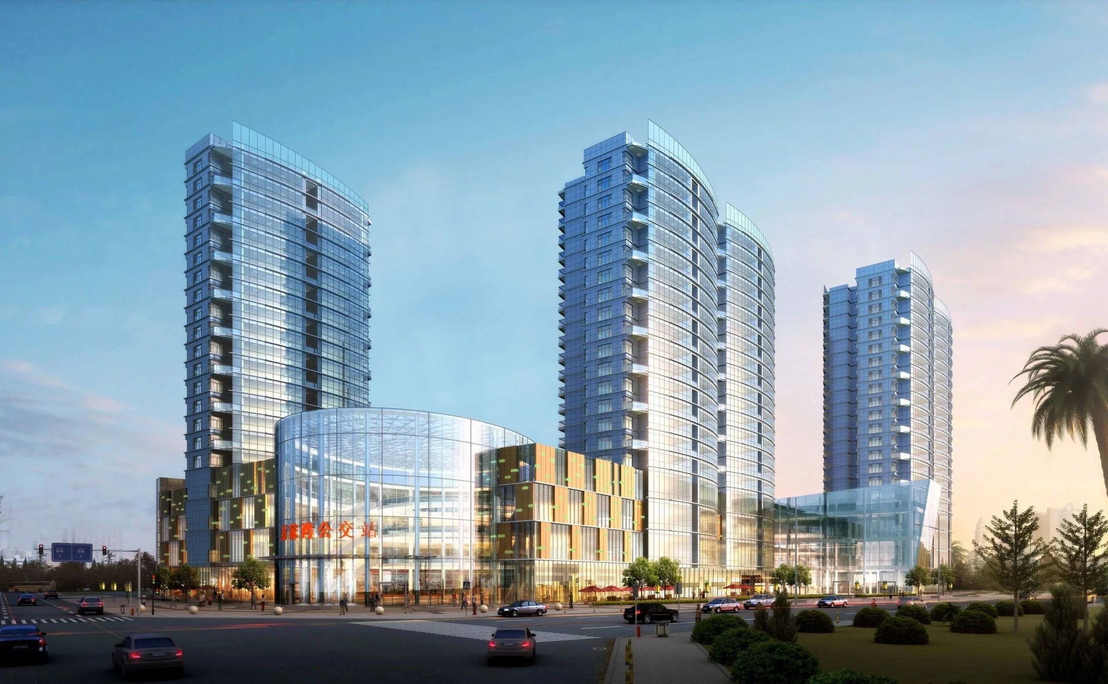 A modern glass skyscraper complex with multiple towers and a circular glass entrance, surrounded by a street with cars and greenery, during sunset.