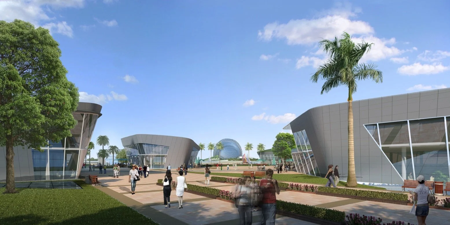 A modern outdoor plaza with uniquely shaped glass buildings, palm trees, and people walking on paved pathways under a blue sky with scattered clouds.
