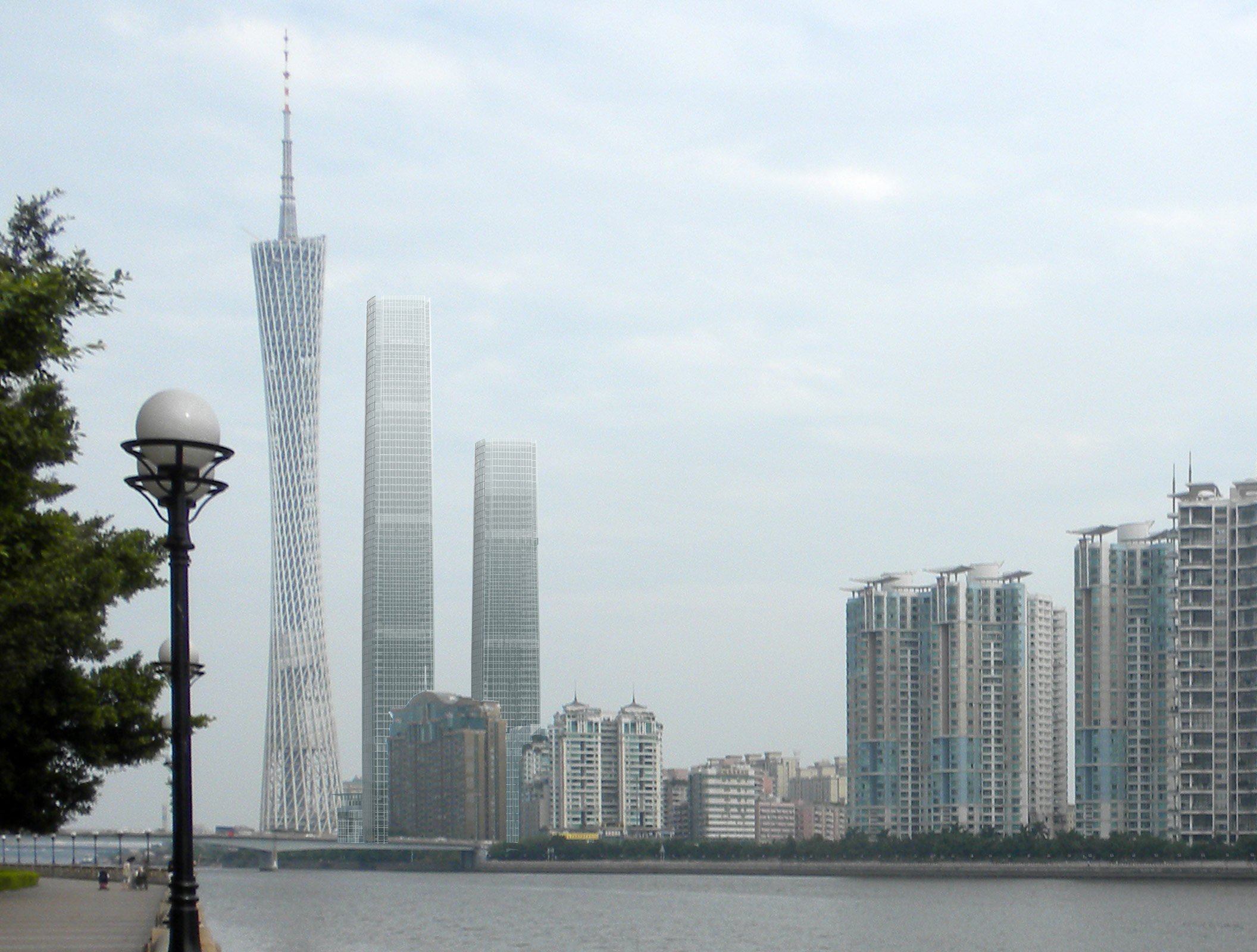 View of modern skyscrapers and high-rise buildings along a riverfront in a cityscape.