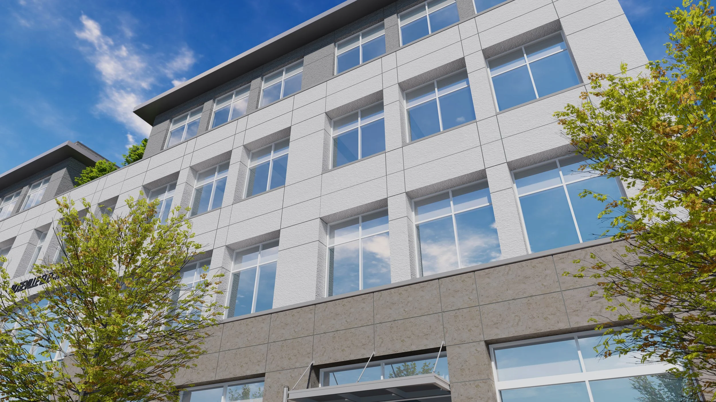 Low-angle view of a modern multi-story building with large windows, tree branches in the foreground, and a blue sky with scattered clouds.