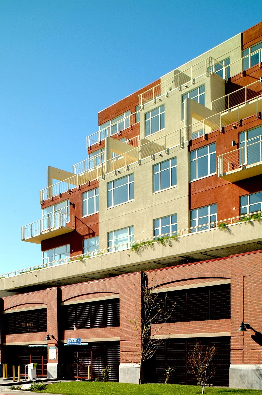A multi-story apartment building with balconies, large windows, and an underground parking garage.