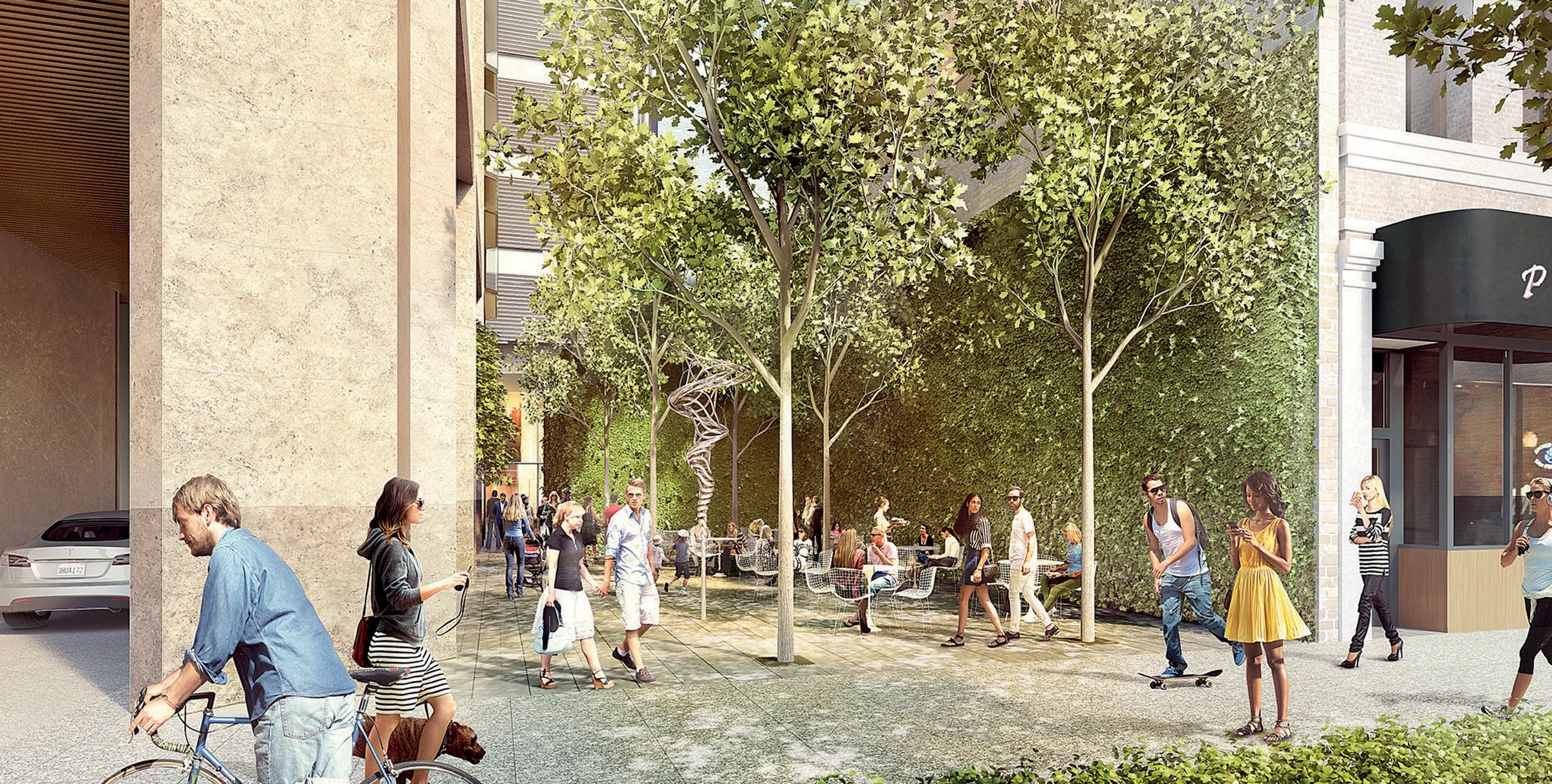 Urban outdoor cafe with people walking and riding bikes, surrounded by green trees and a building with a green wall.