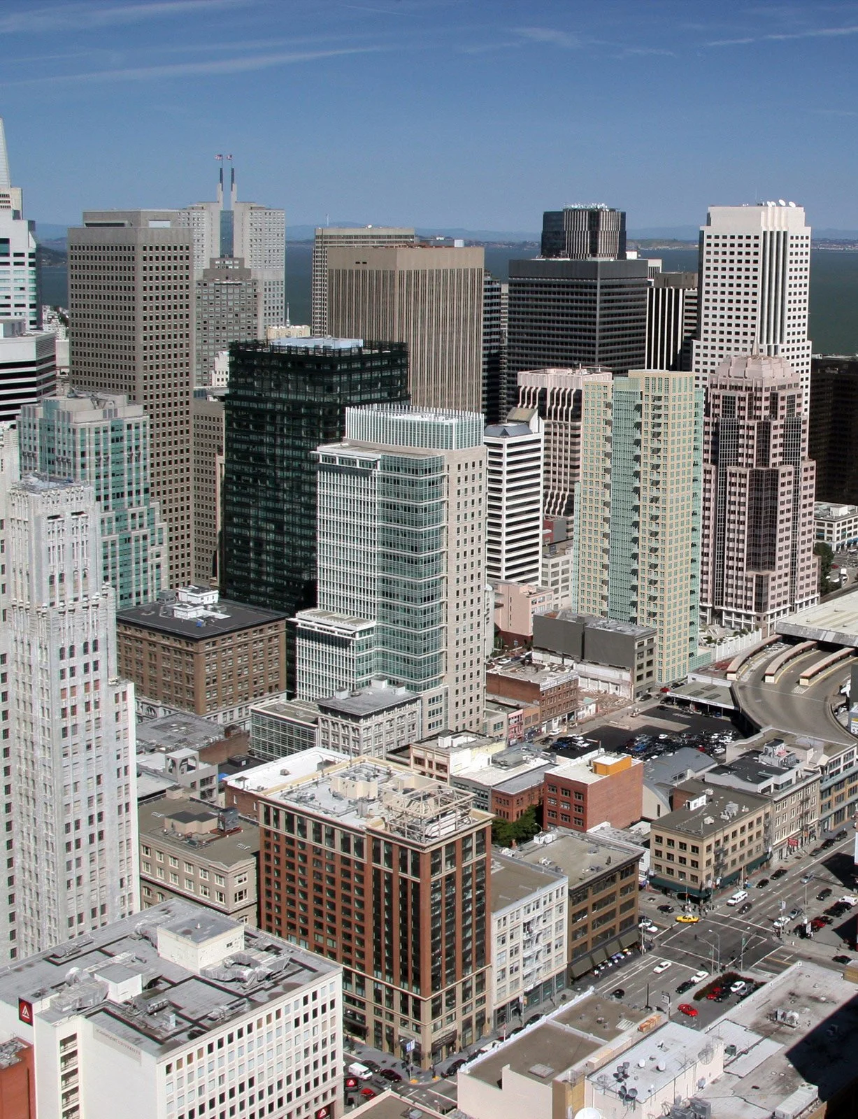 City skyline with tall modern skyscrapers and a view of the bay in the background.