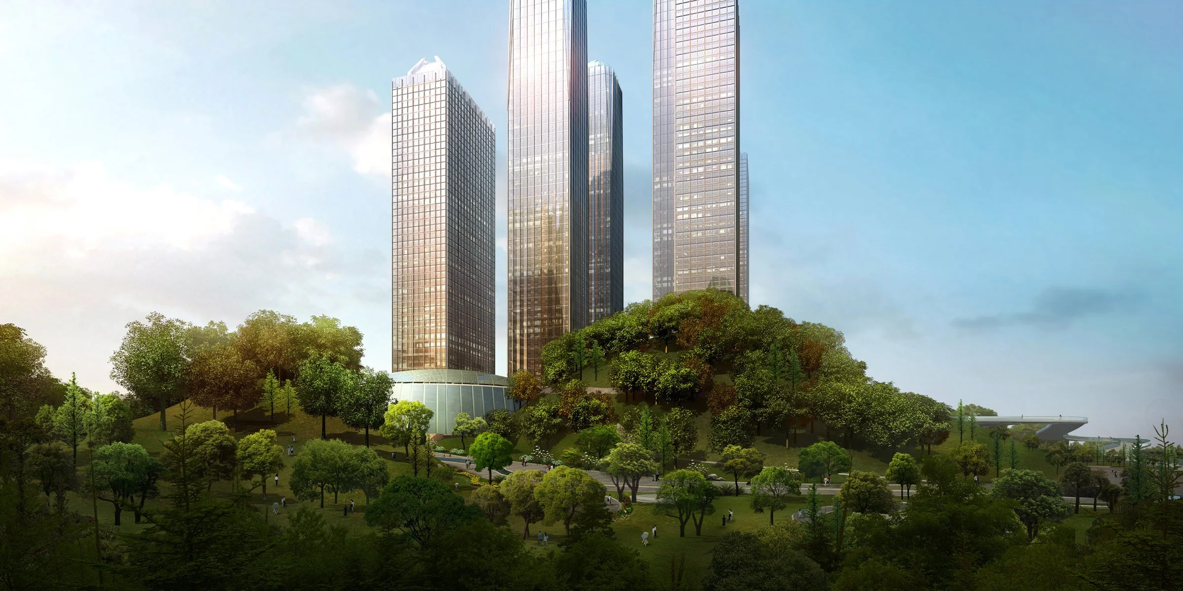 Four tall modern skyscrapers surrounded by lush green trees and a park in the foreground on a partly cloudy day.