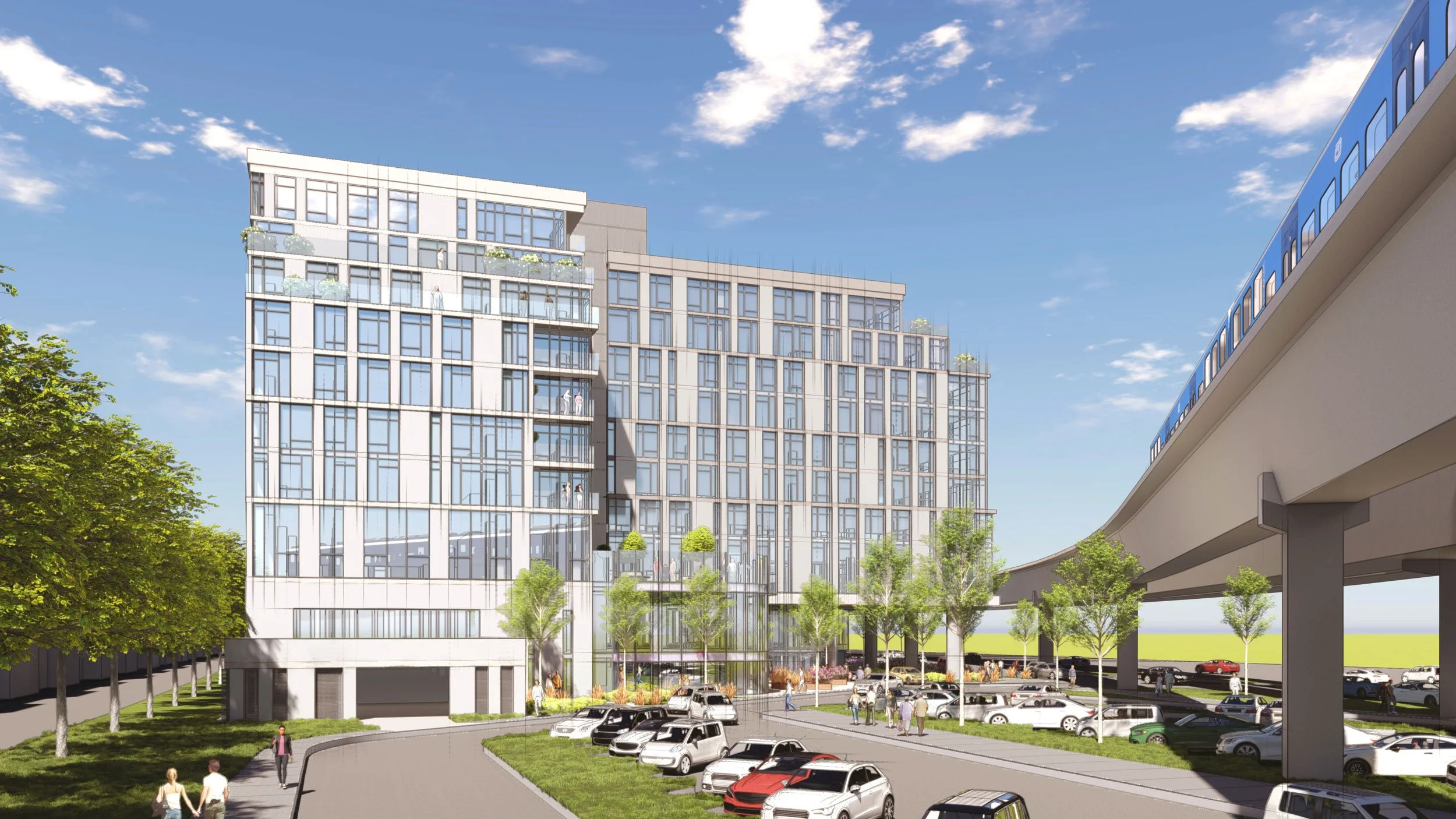 A modern multi-story apartment building with large glass windows and balconies, surrounded by a parking lot with numerous cars, trees, and a green landscape under a clear blue sky.