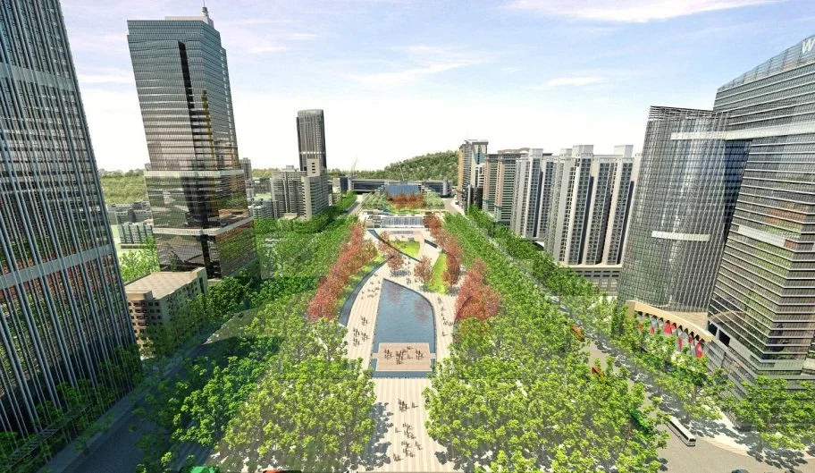 Aerial view of a modern city park with trees, walkways, a water feature, and surrounding high-rise office buildings.