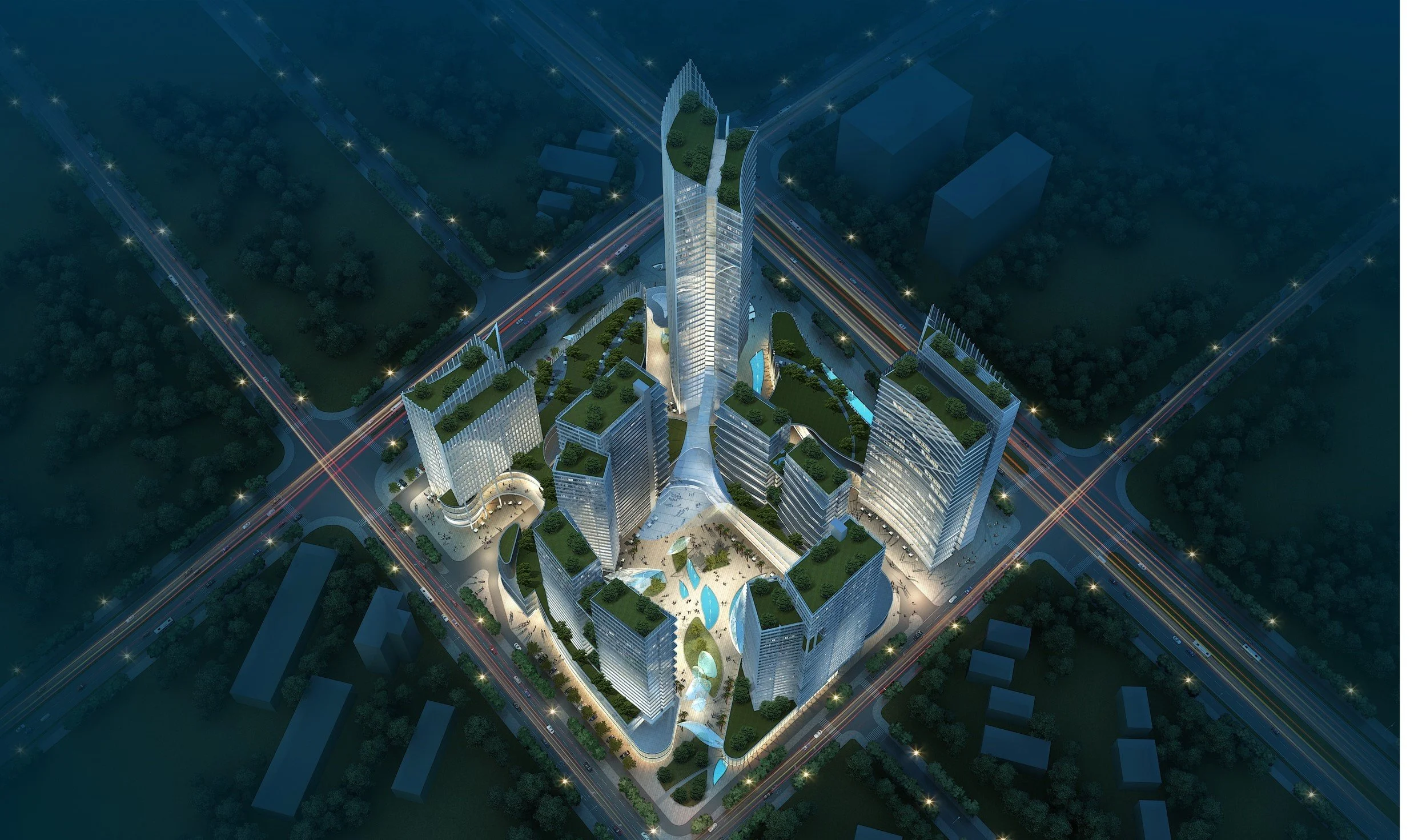 Nighttime aerial view of a modern, illuminated high-rise building complex with green rooftops and water features, surrounded by streets and other low-rise structures.