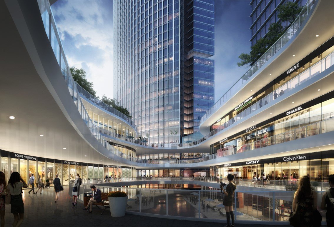 A modern multi-level shopping mall with high-end fashion stores like Louis Vuitton, Gucci, Chanel, and Dior, featuring glass storefronts and people walking around.