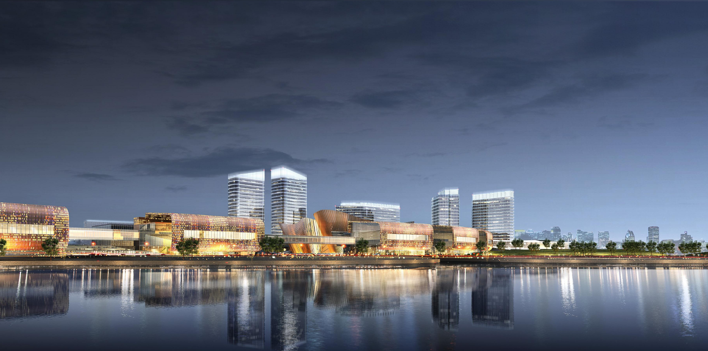 Nighttime view of a modern city skyline with tall illuminated buildings and reflections on the water in the foreground