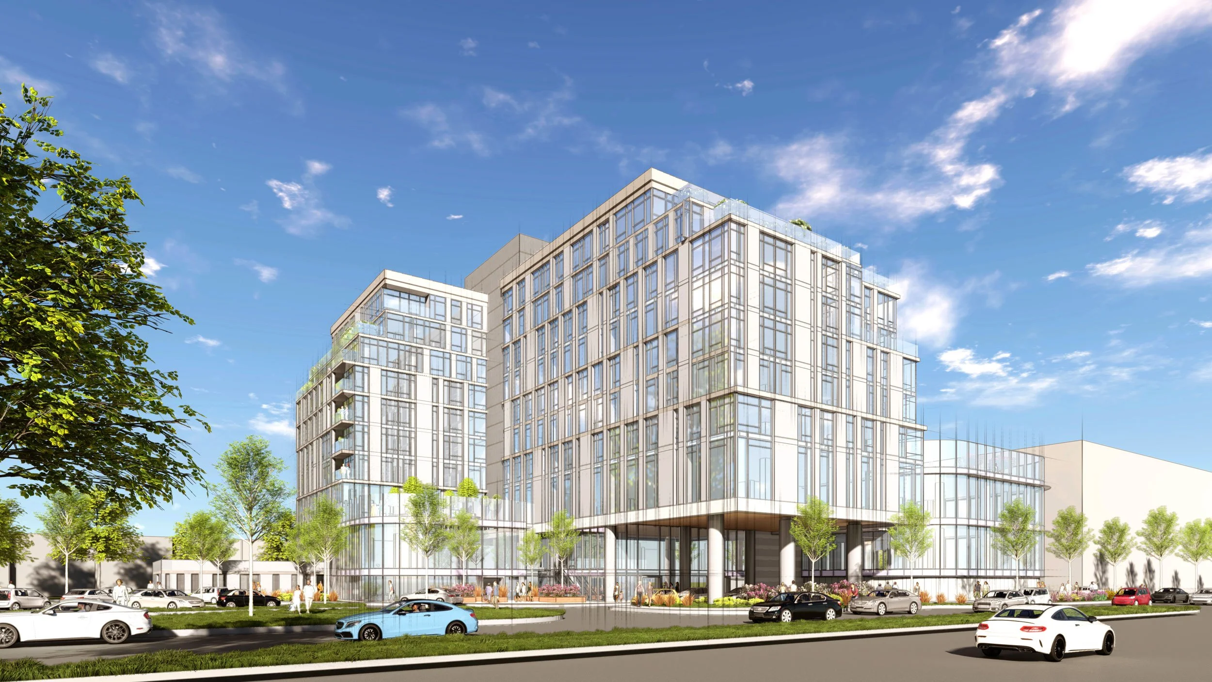 A modern multi-story office or residential building with glass windows and trees in the foreground, cars parked along the street, under a blue sky with some clouds.