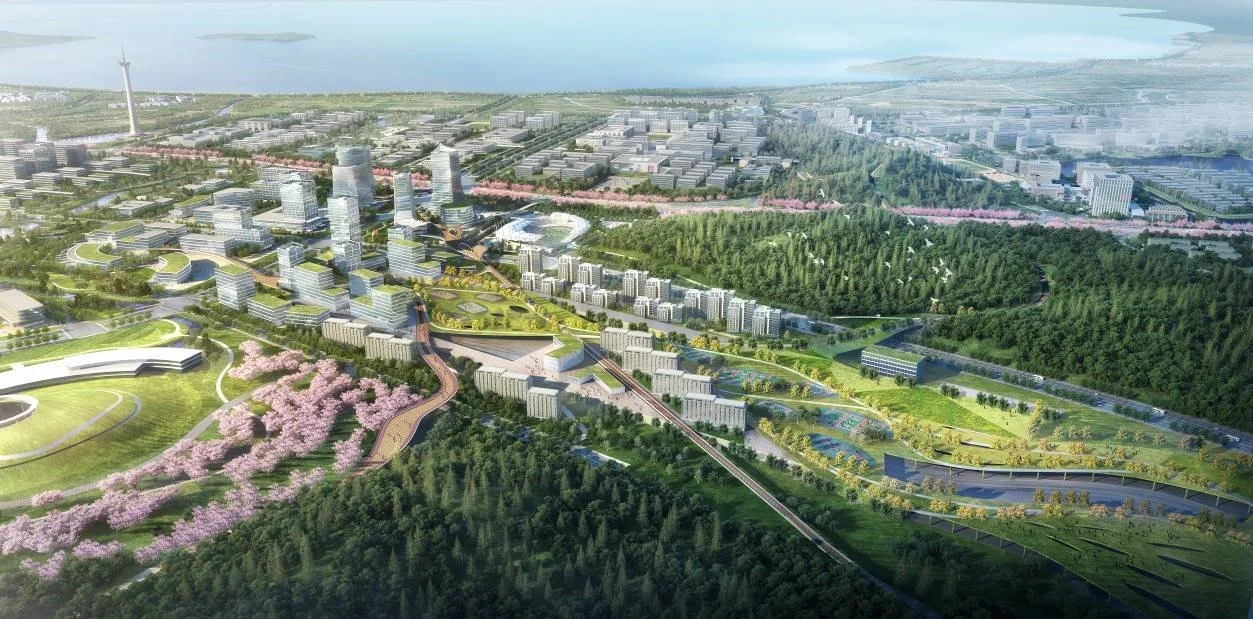 A detailed aerial view of a modern city with high-rise buildings, green parks, and roads, surrounded by natural landscapes and water bodies.