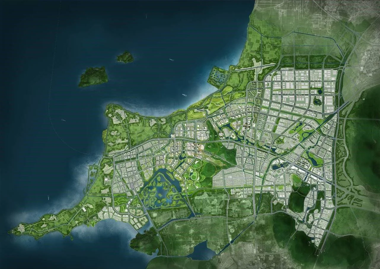 A detailed city map with green parks, water bodies, and a grid of streets and buildings, bordered by water on one side and lush green areas on the other.