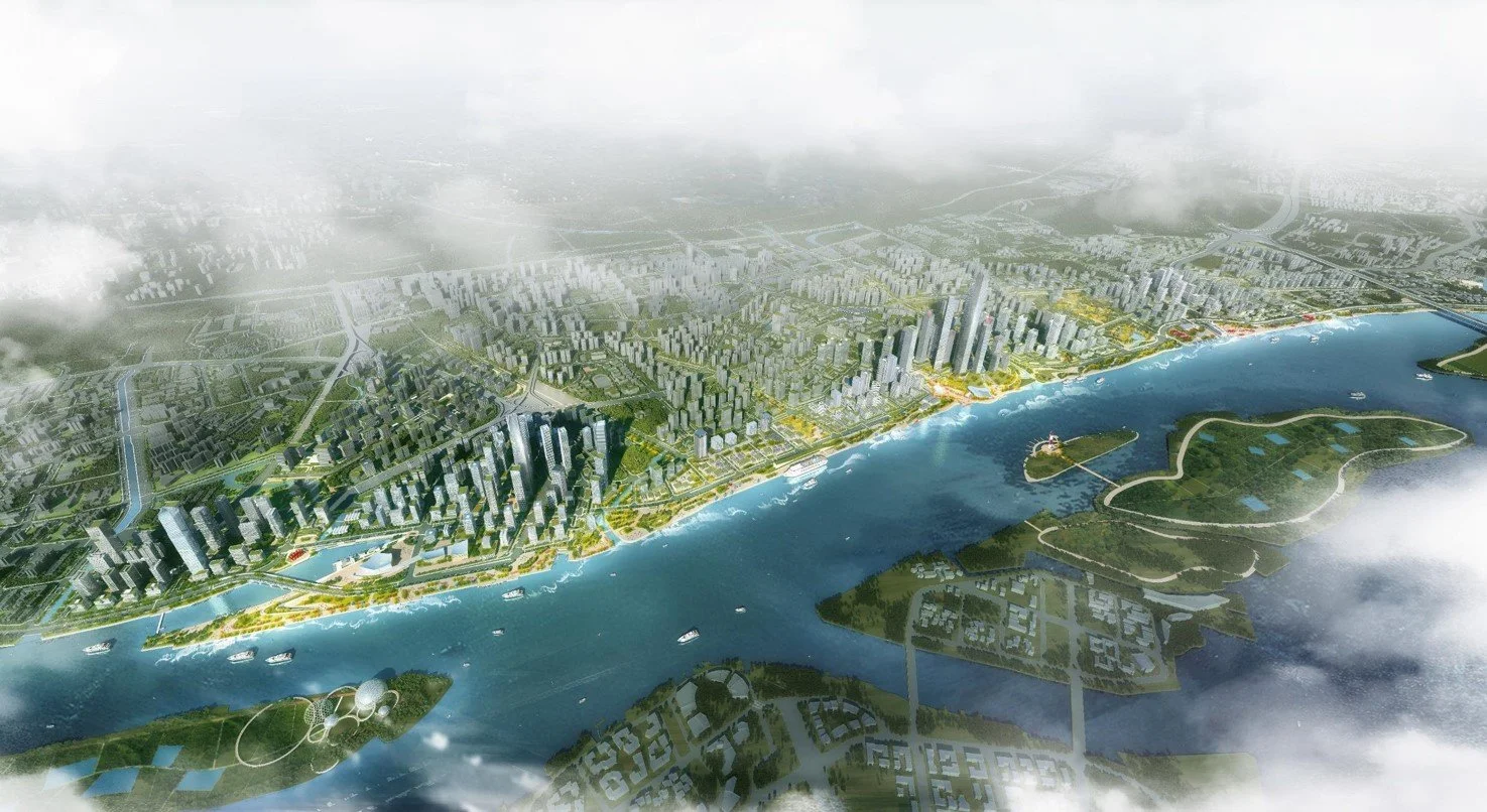 Aerial view of a large city with numerous high-rise buildings along a river, with green parks, roads, and some islands in the river, partially covered by clouds.