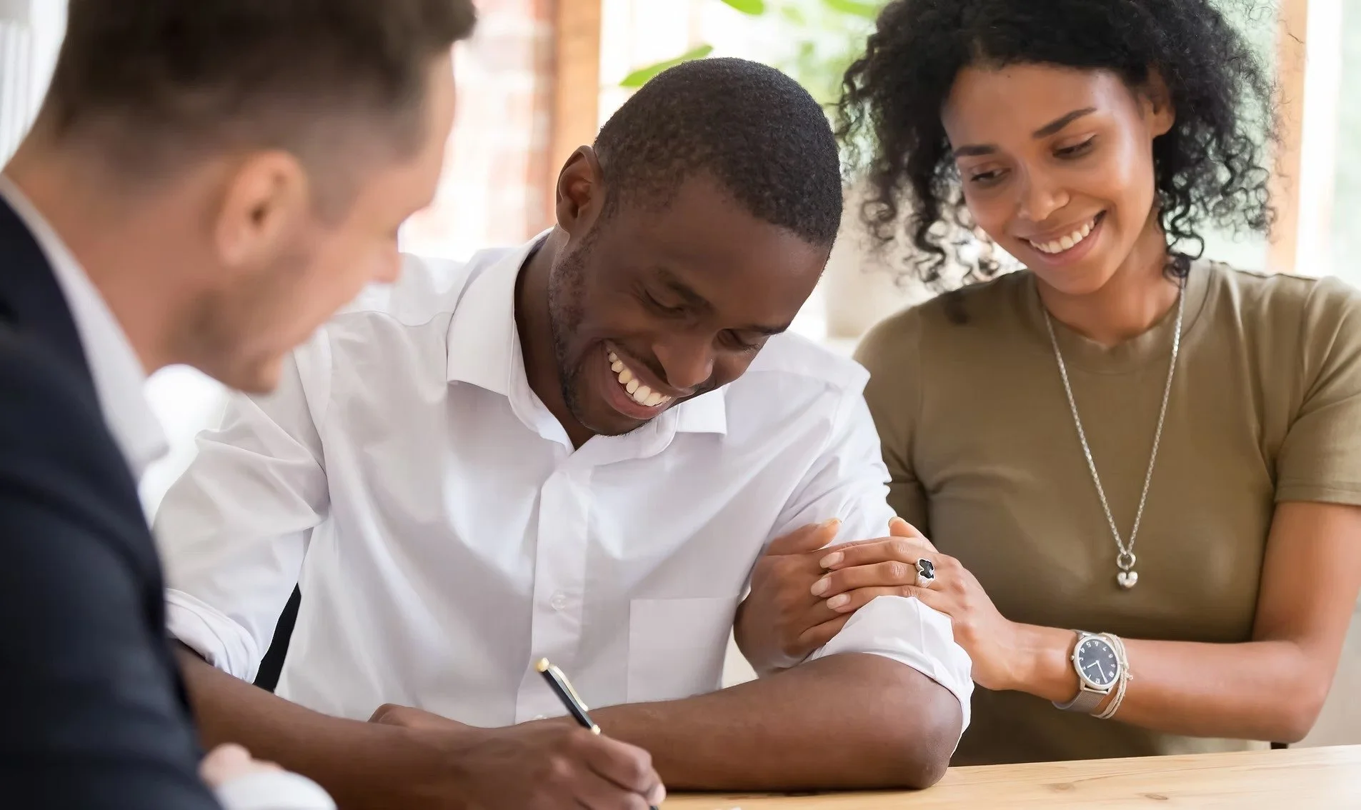 Happy tenants signing a lease agreement with a property manager during a residential rental process.