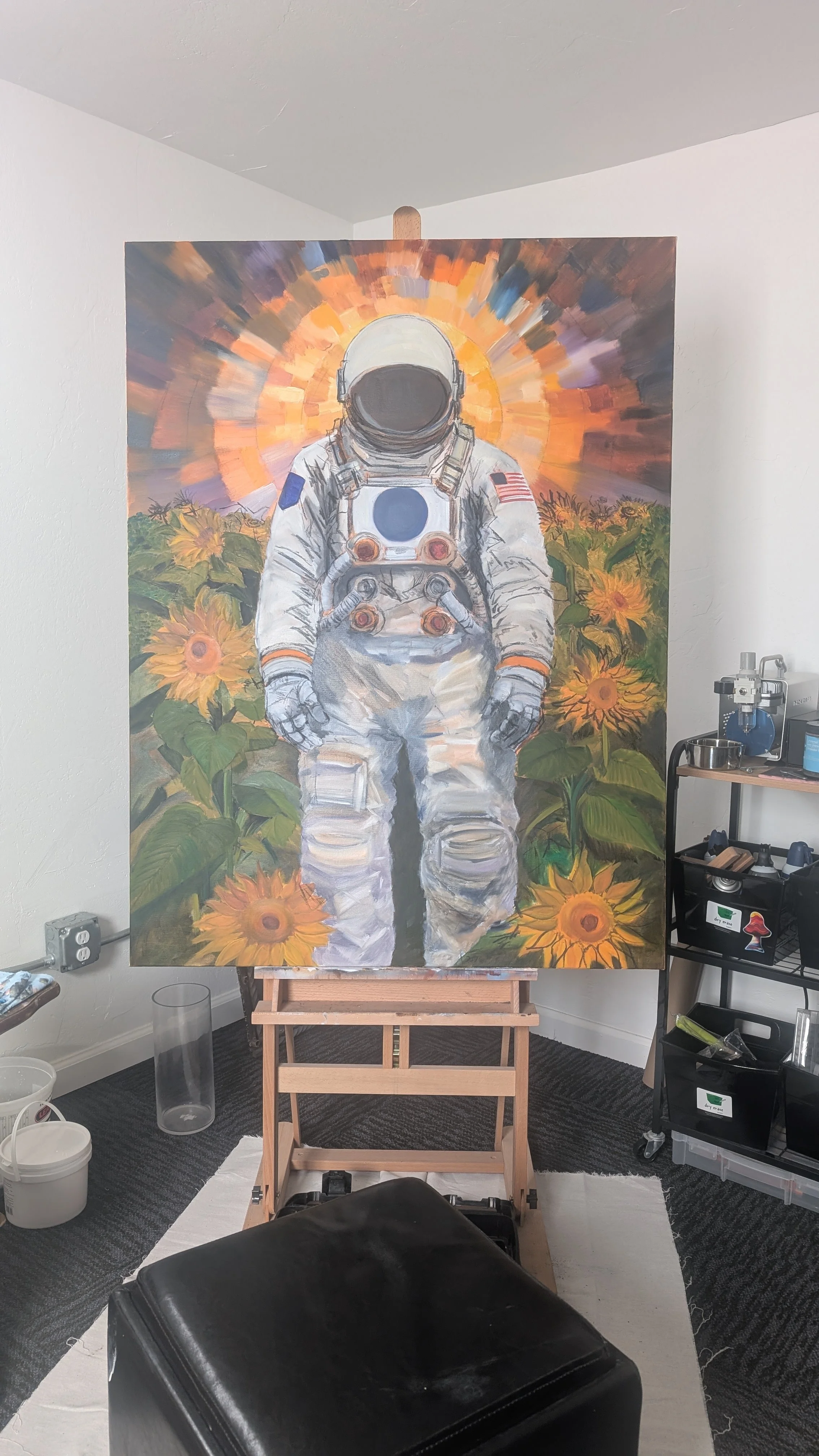 Painting of an astronaut standing in a field of sunflowers with a colorful sunrise or sunset in the background.
