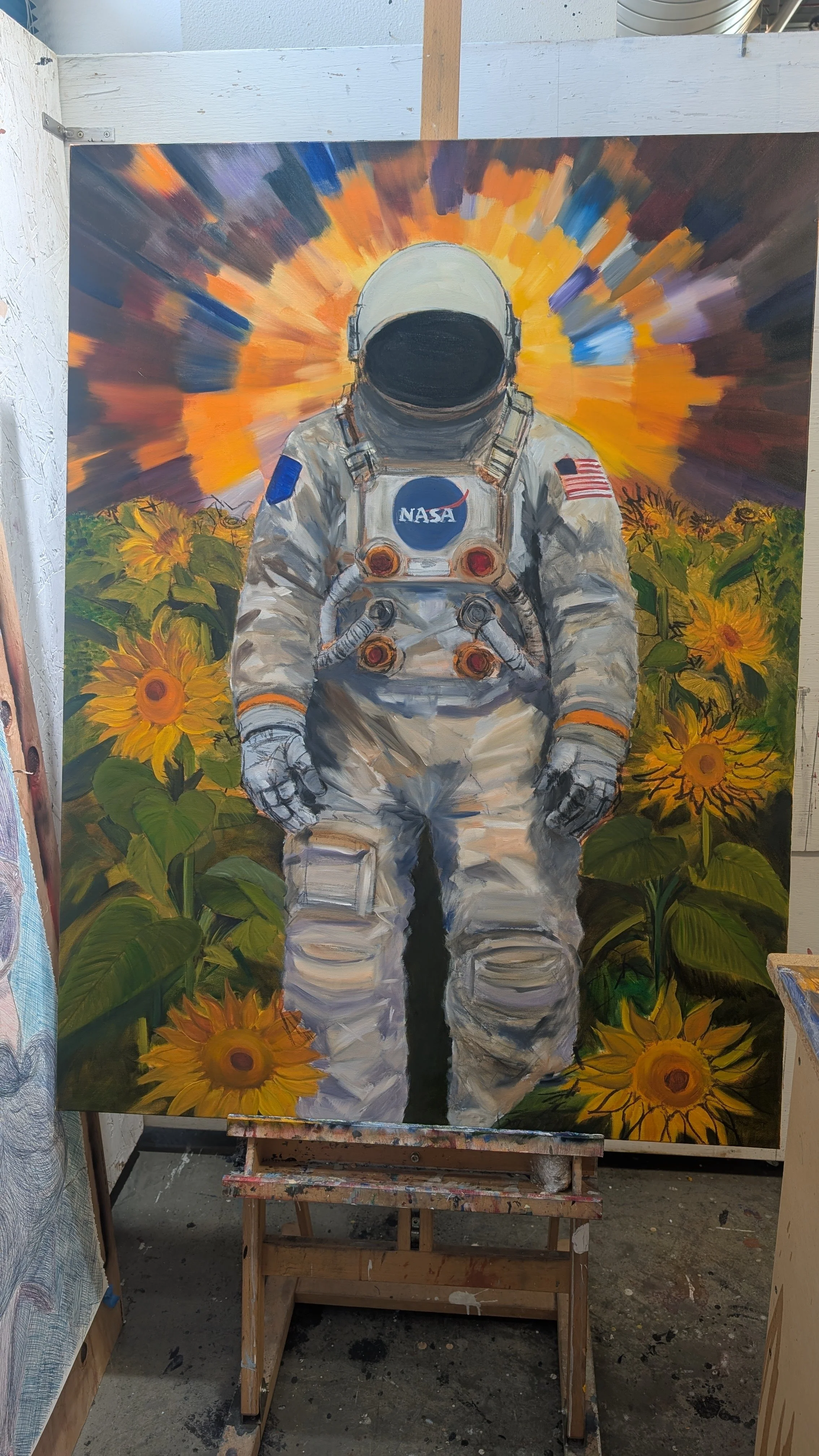 Painting of an astronaut in a white suit with NASA logo, surrounded by vibrant sunflowers and a colorful sky with an explosion of orange, blue, and purple in the background.