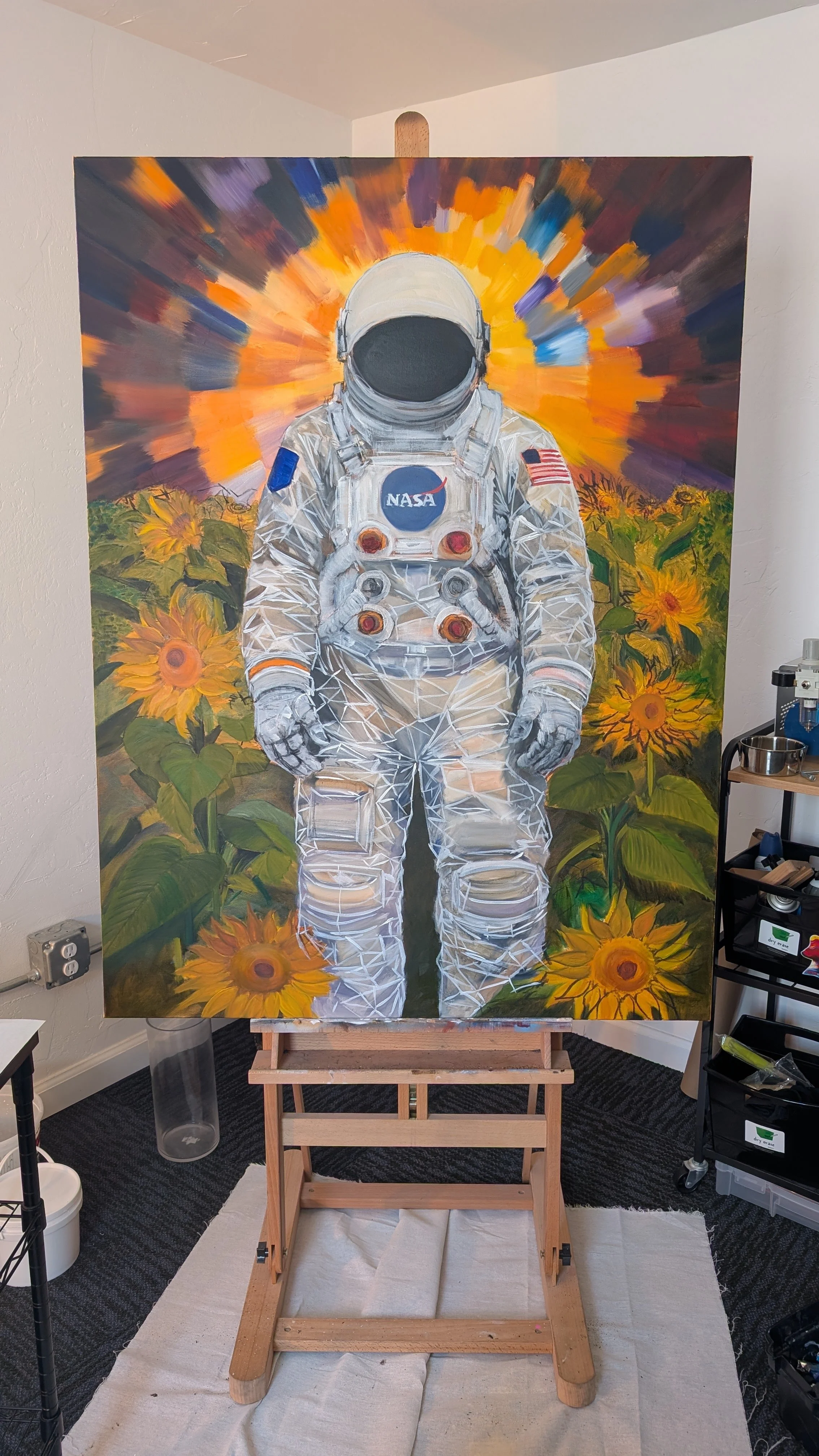 A painting of an astronaut in a white spacesuit standing among sunflowers, with an orange and purple explosion-like background.