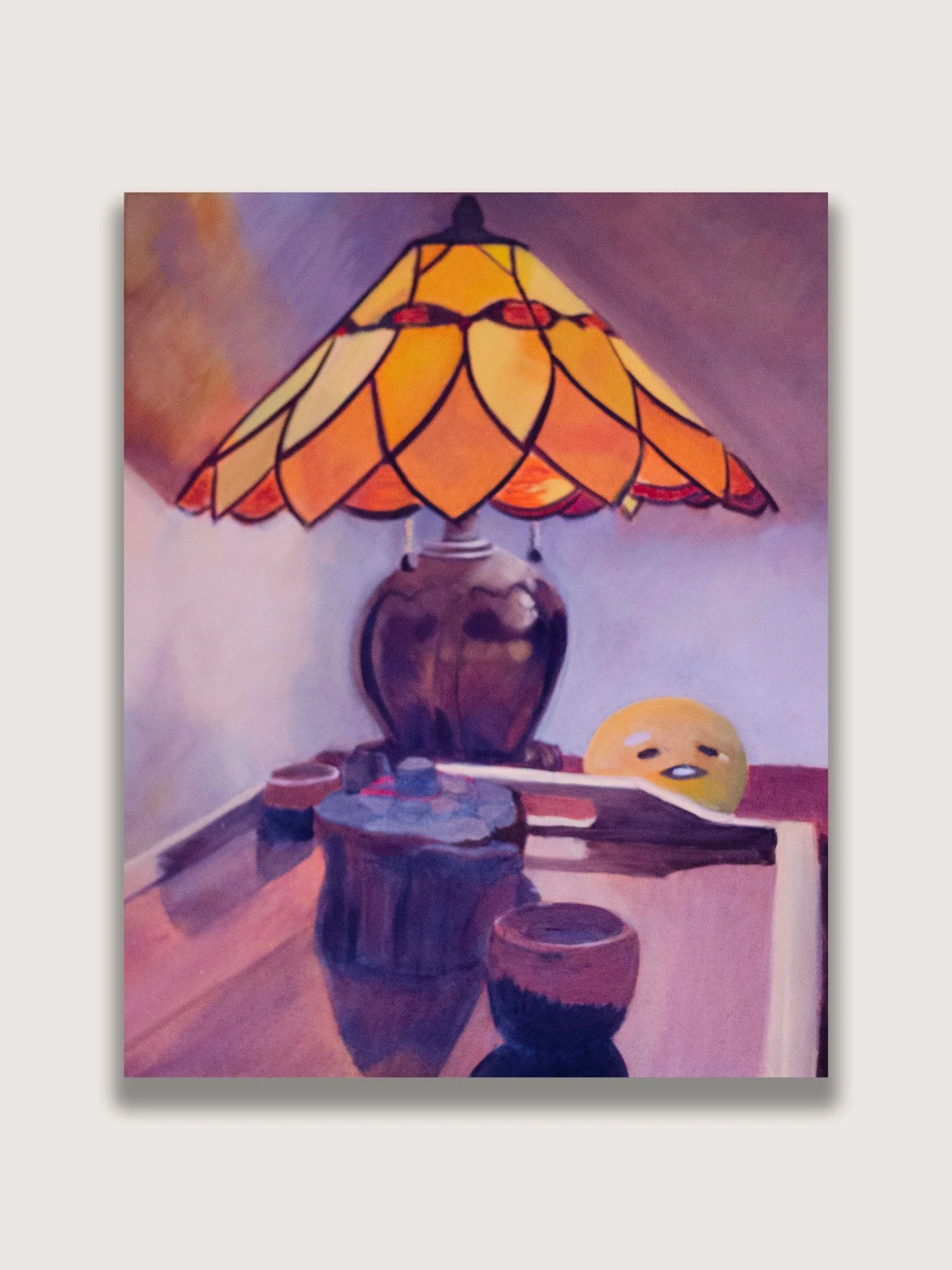 Contemporary oil painting featuring a glowing stained-glass lamp, books, ceramics, and a playful Gudetama character. A cozy still life that captures themes of quiet reflection, domestic space, and companionship.