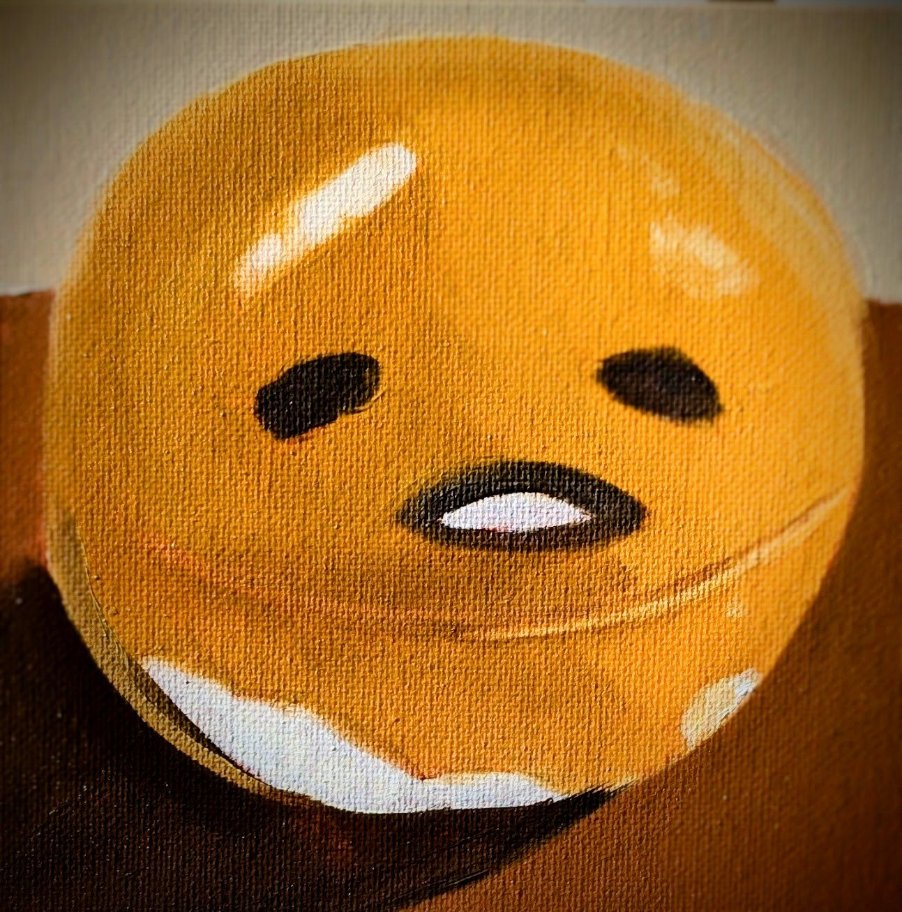 A round, orange Halloween pumpkin with cartoon-like facial features, including black oval eyes and a small, open mouth.