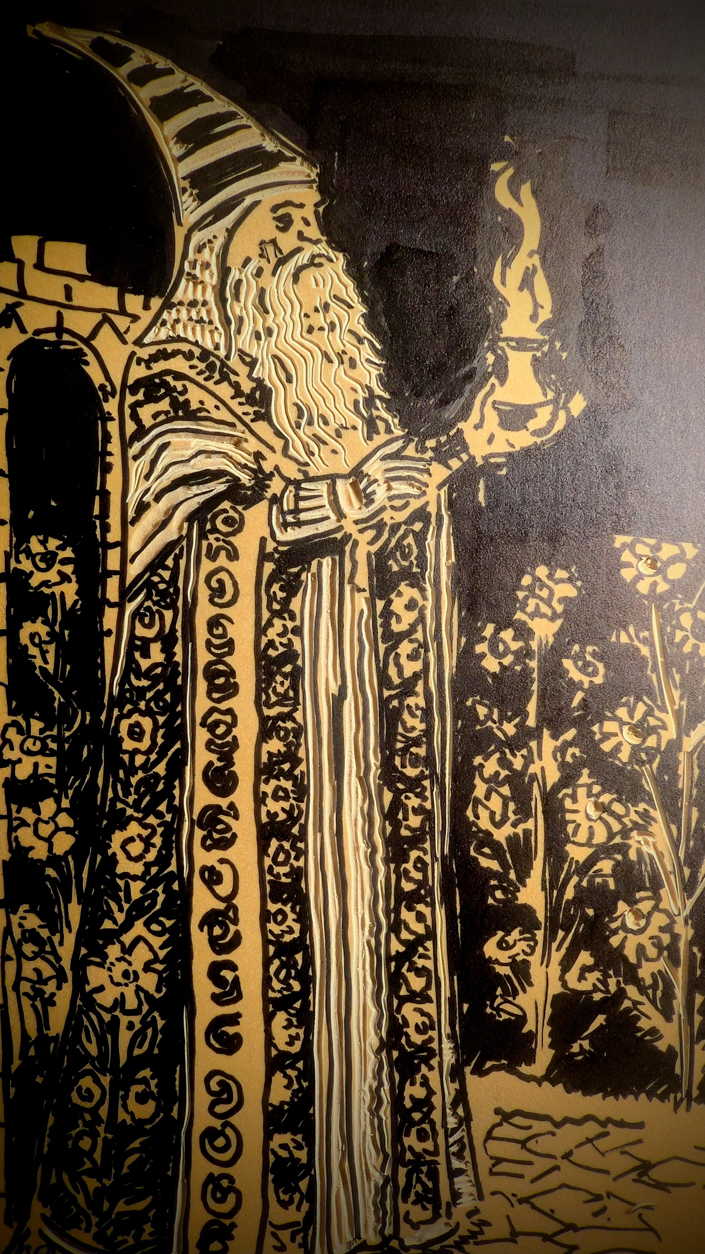 Black and gold illustration of a woman with long hair and a hat, standing with flowers and trees in the background.