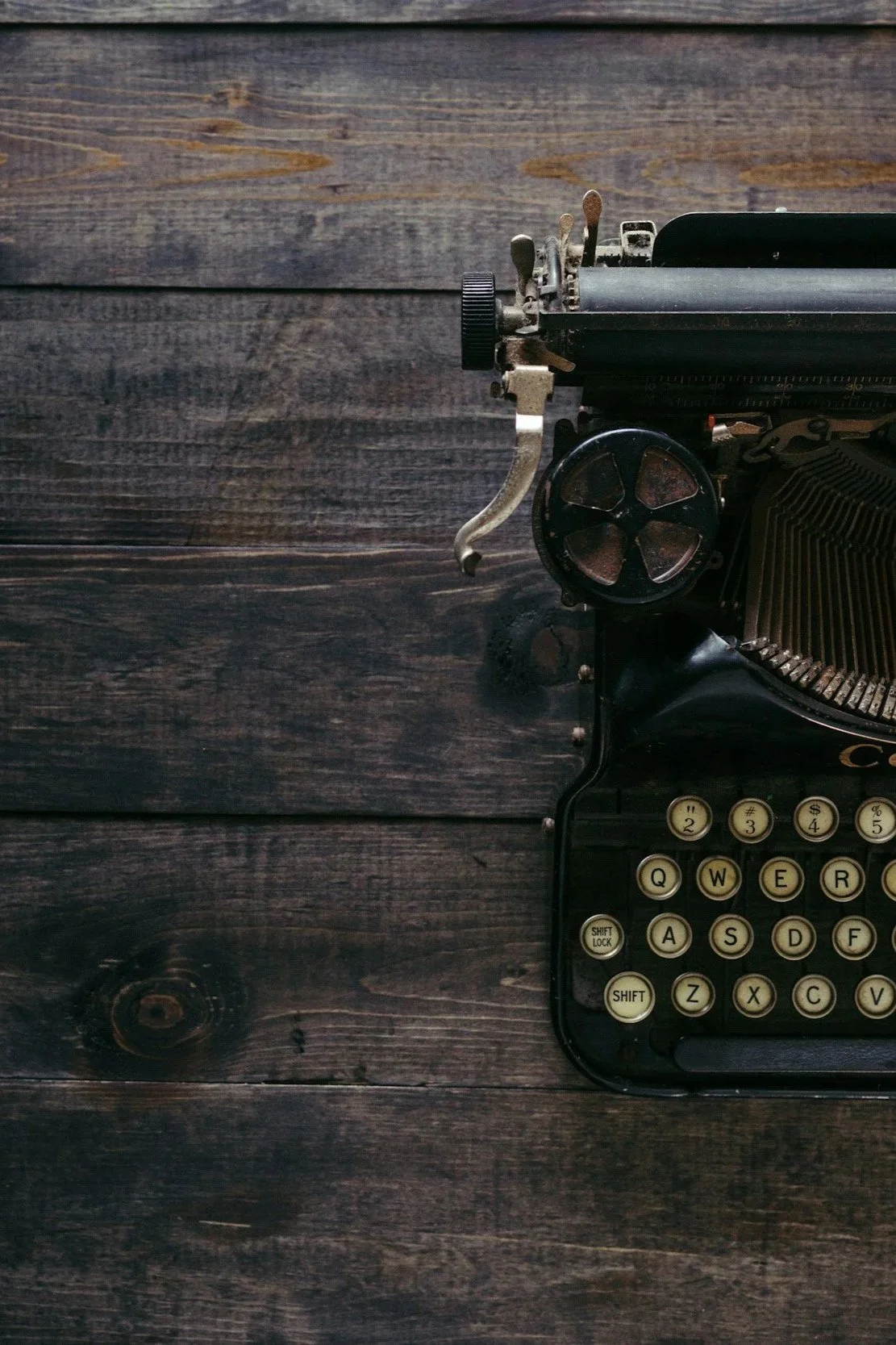 An antique typewriter on a wooden tabletop
