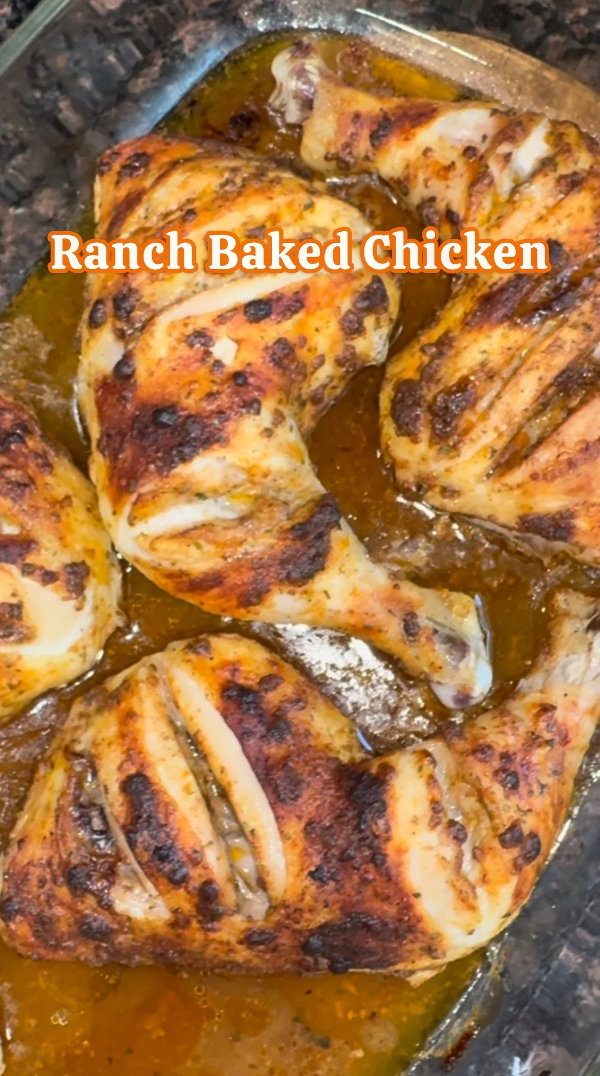 Baked ranch-seasoned chicken quarters with golden brown, seasoned skin in a glass baking dish with juices.