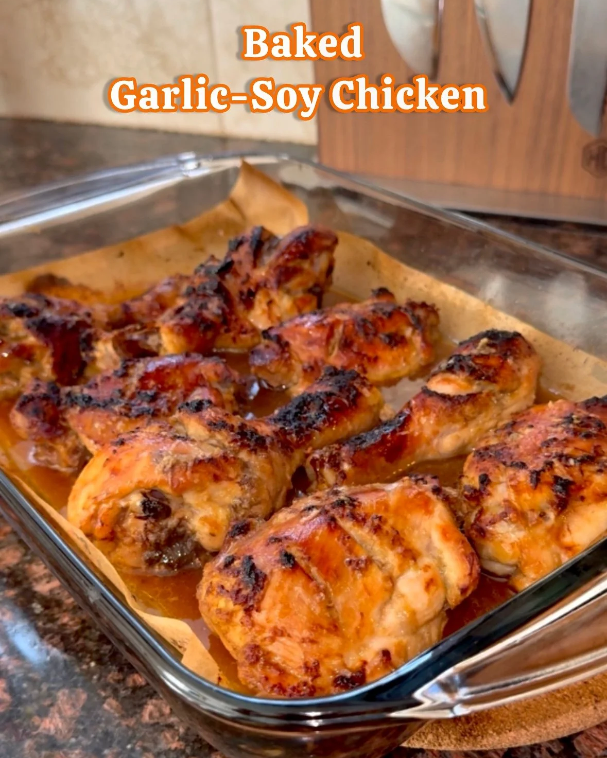 Baked garlic-soy chicken pieces in a glass baking dish with caramelized edges.