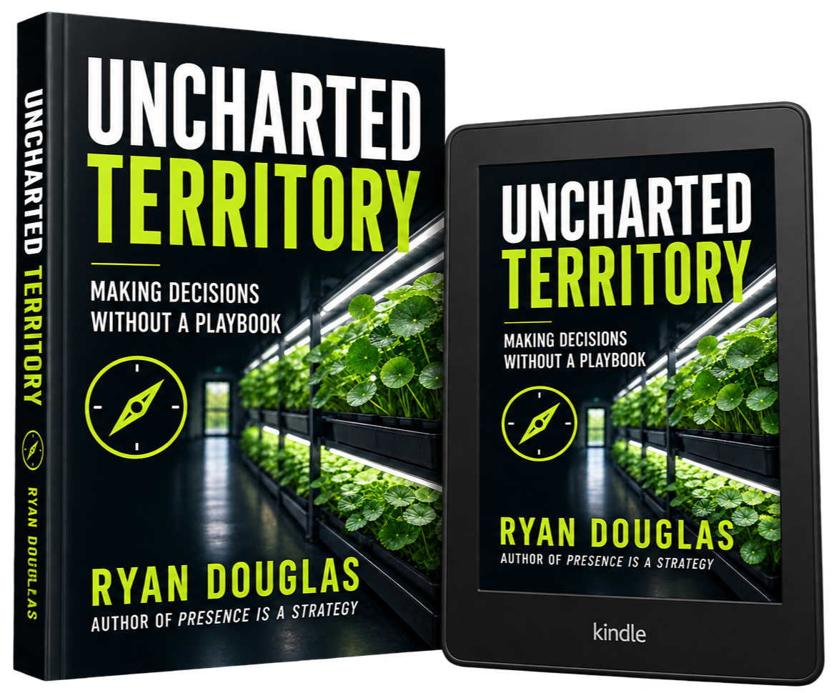 Book titled "Uncharted Territory" with subtitle "Making Decisions Without a Playbook" and author Ryan Douglas, featuring an e-book version on a Kindle device. The cover shows an indoor greenhouse with plants in rows.