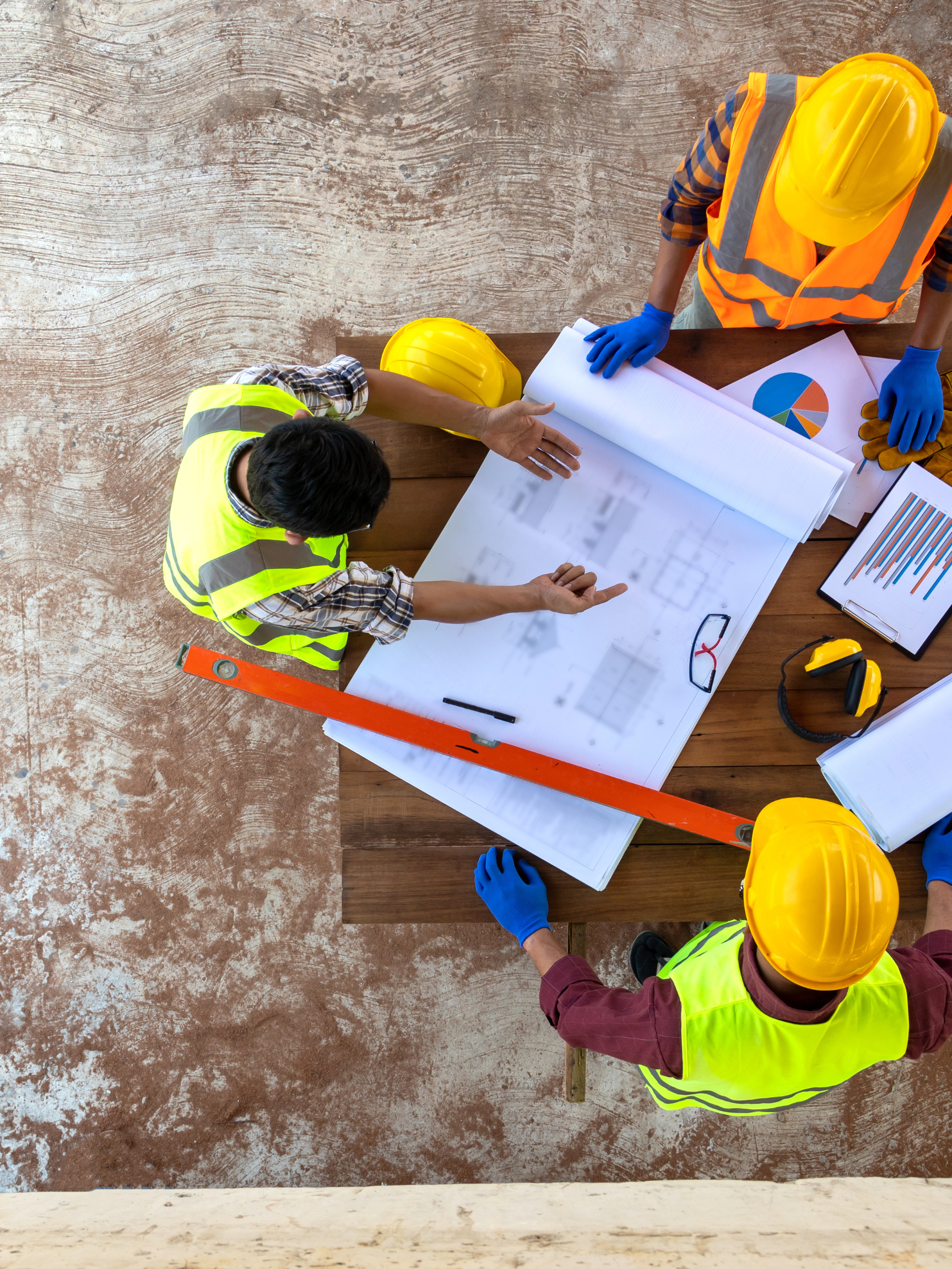 Construction professionals reviewing project plans and field documentation at a job site.