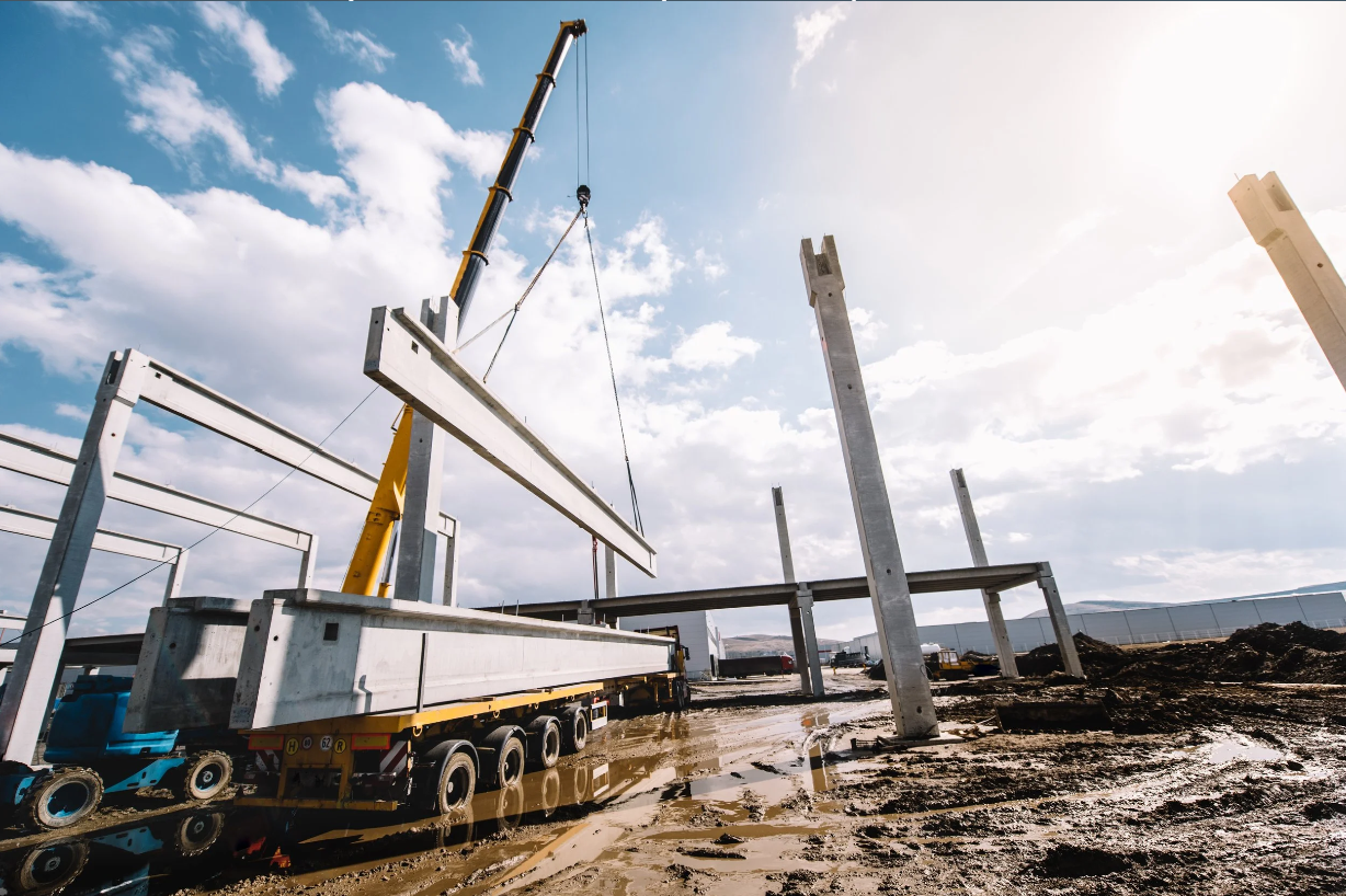 Crane lifting structural components into place at an active commercial construction site.