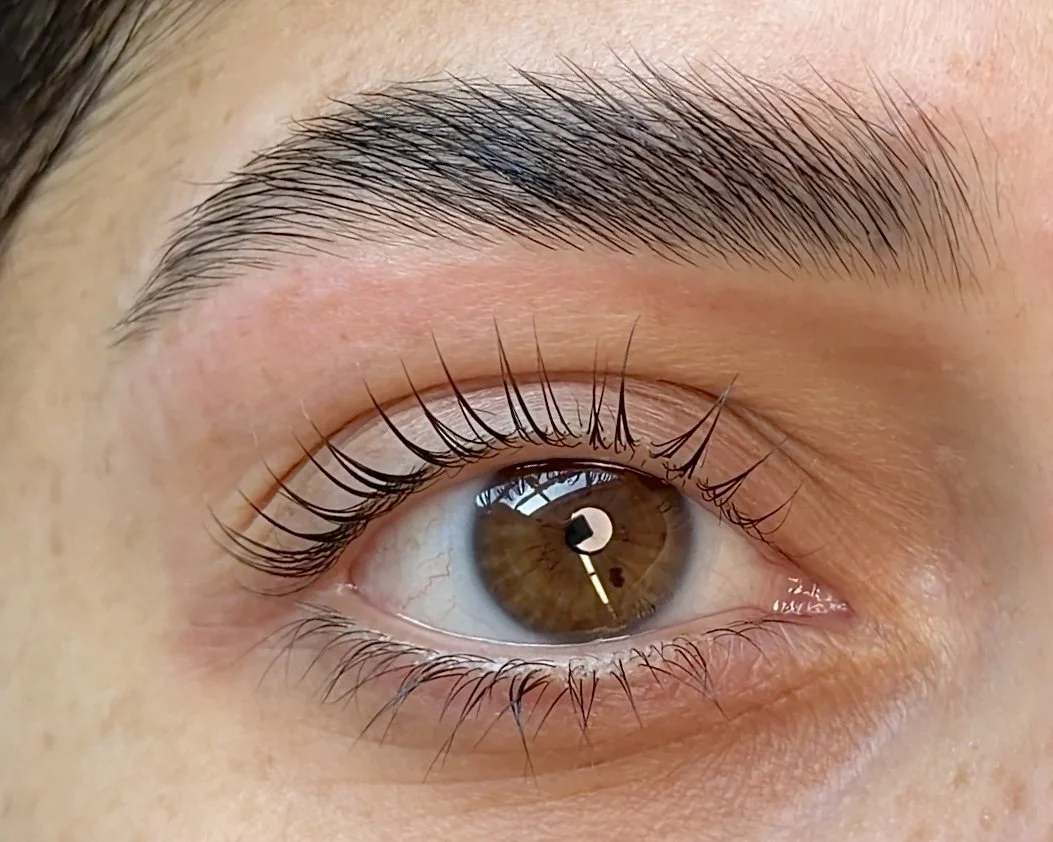 Close-up of a brown eye with visible eyelashes and eyebrow.